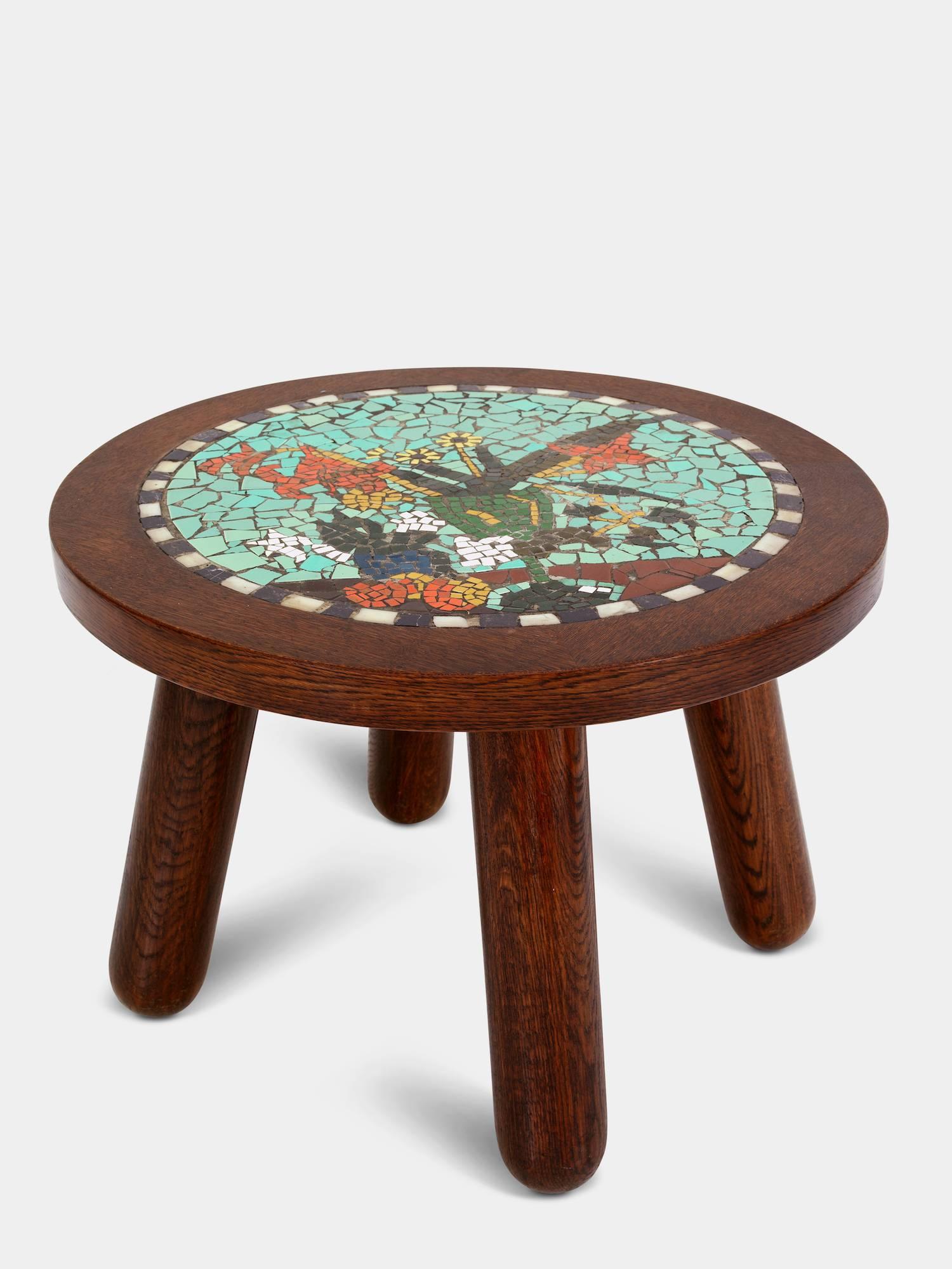 Circular coffee table of solid oak mounted on round club legs. Tabletop decorated with mosaik.
Designed and manufactured in the 1940s.