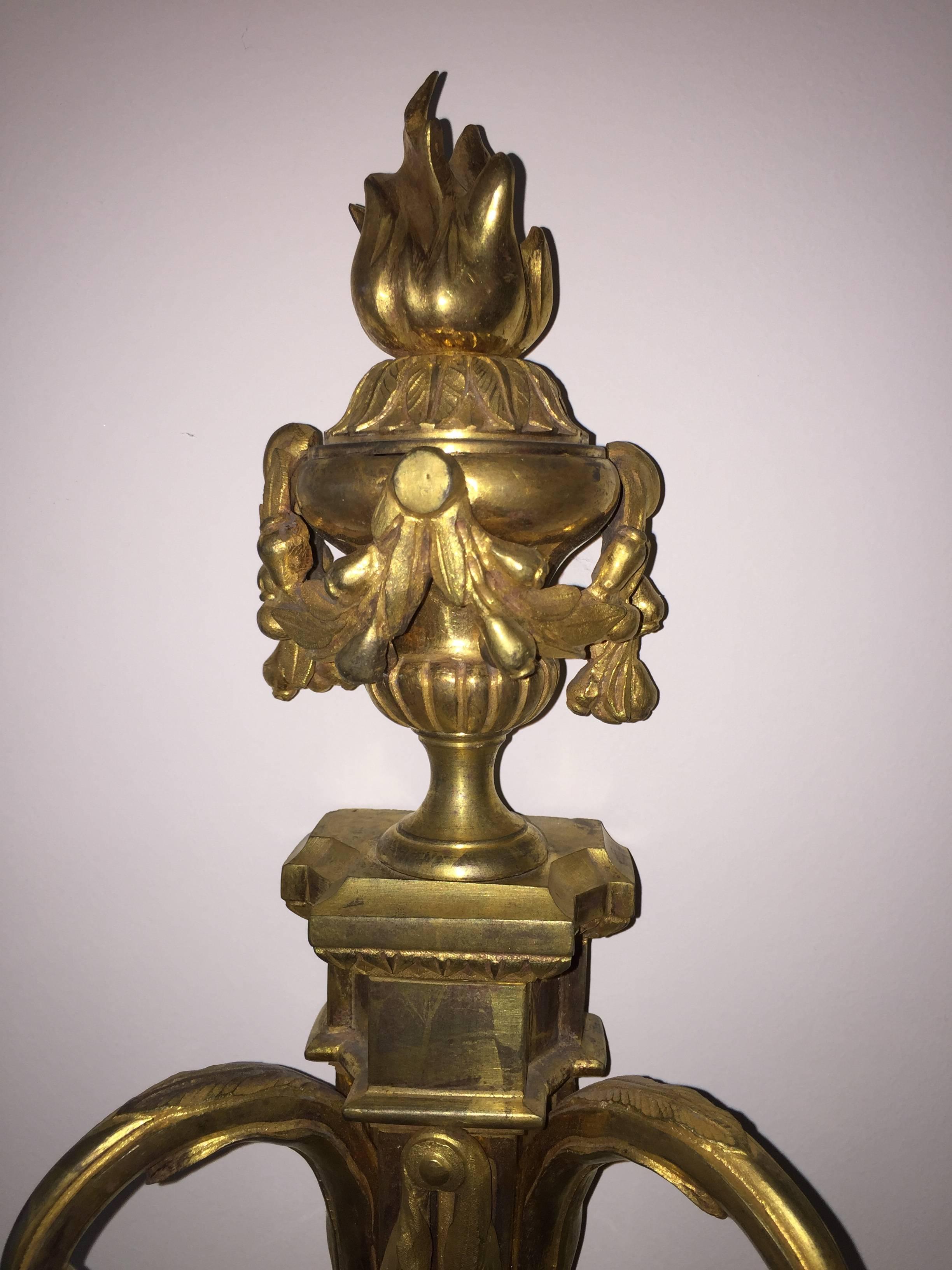 Large pair of candlesticks wall lights Louis XVI of the late 18th century, French origin. Two carved and gilded bronze arms. The fluted barrel and garlands of foliage. They are topped with a firepot also surrounded by garlands.