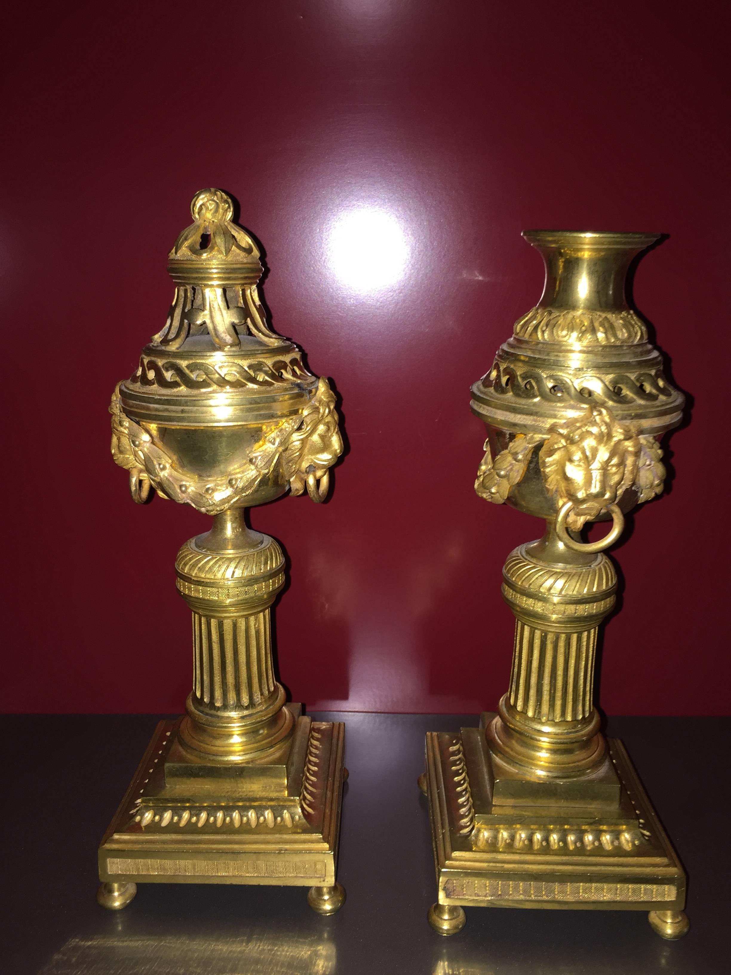 Pair of incense burners. The pot-pourri is forming candlesticks, Louis XVI of the late eighteenth century, French origin. Bonze finely carved and gilded lion masks with handles. Bases pedestal decorated with a frieze, fluted.