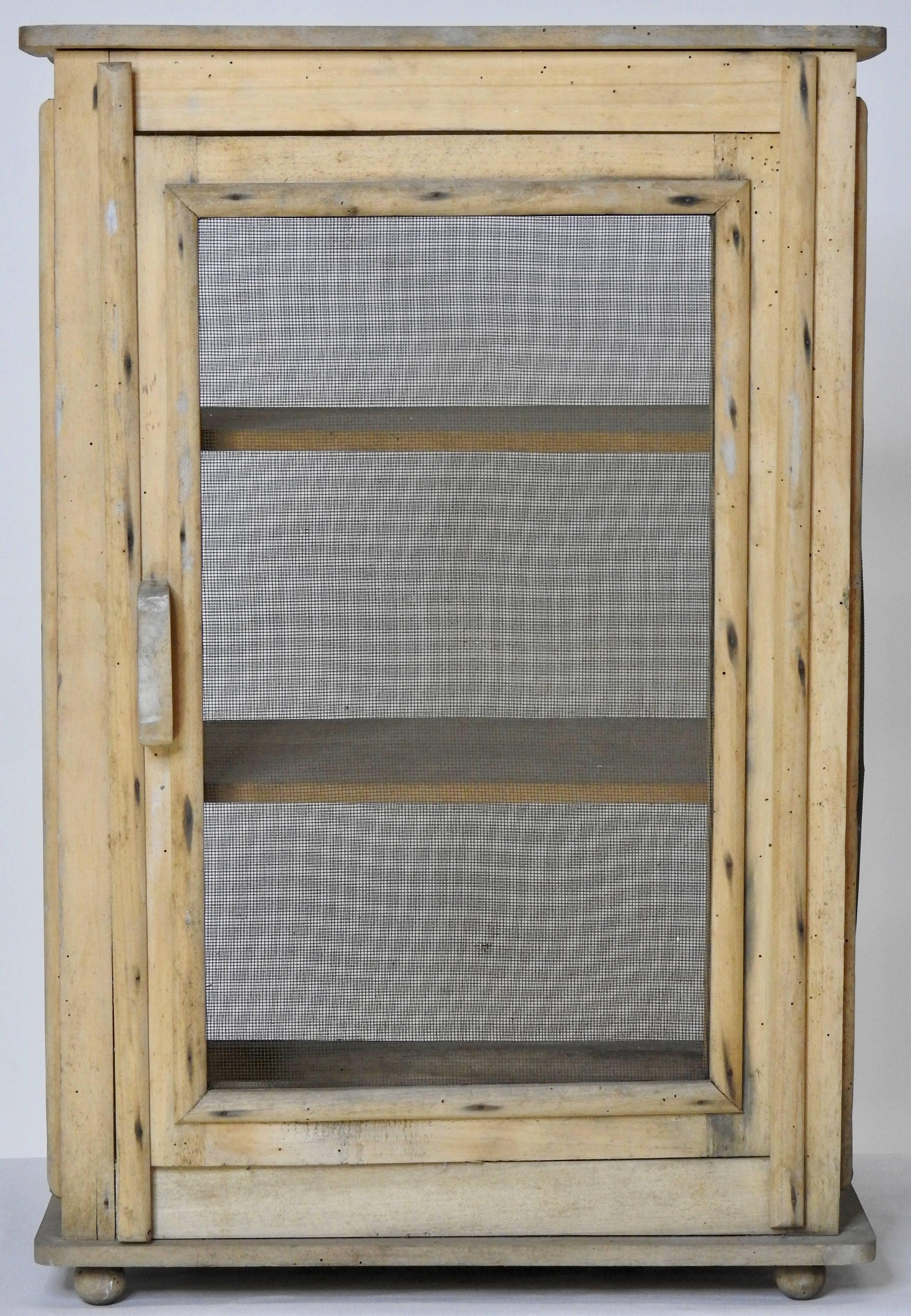 Natural wood and wire screen make up this unique French cheese safe. Wood is very light weight and has not been painted or finished. It sits on four ball feet with the bottom and two shelves above. Has a wooden pull handle to open and a closing