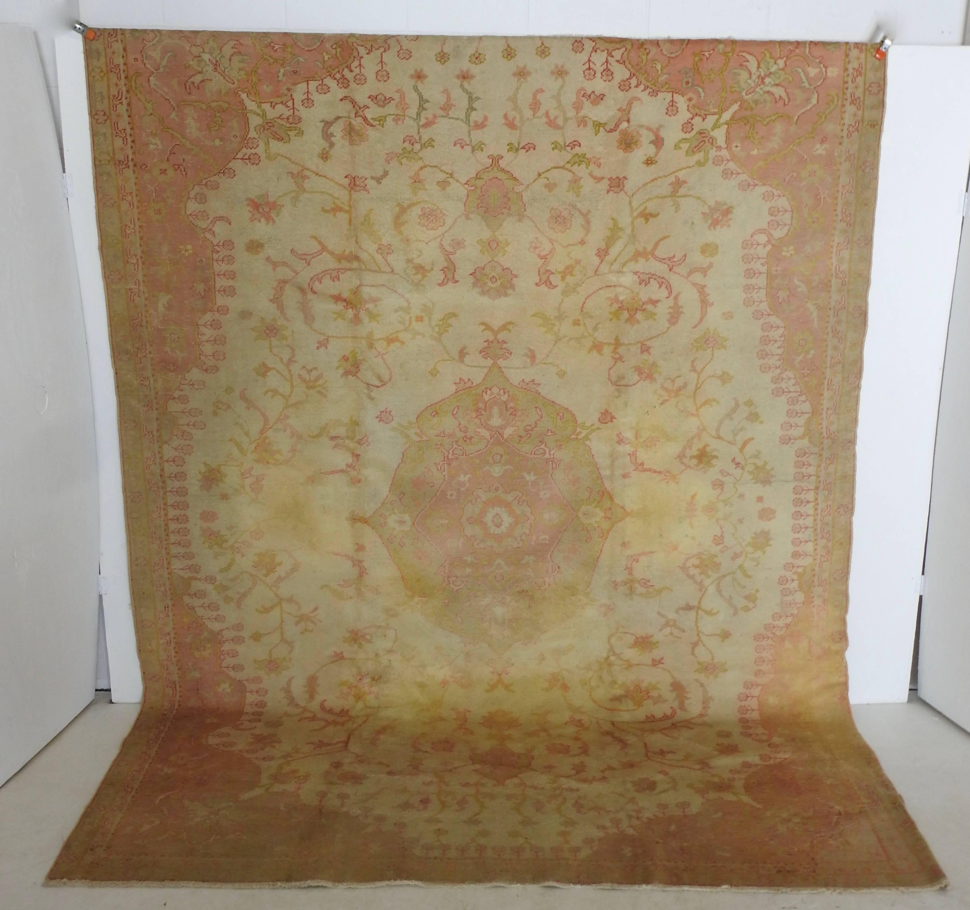 Beautiful soft shades of salmon, cream and gold with a hint of green decorate this stunning rug. Vegetable dyes have gently faded over the years. The rug is made of hand knotted wool with some fringe on the ends. This rug still has many years of