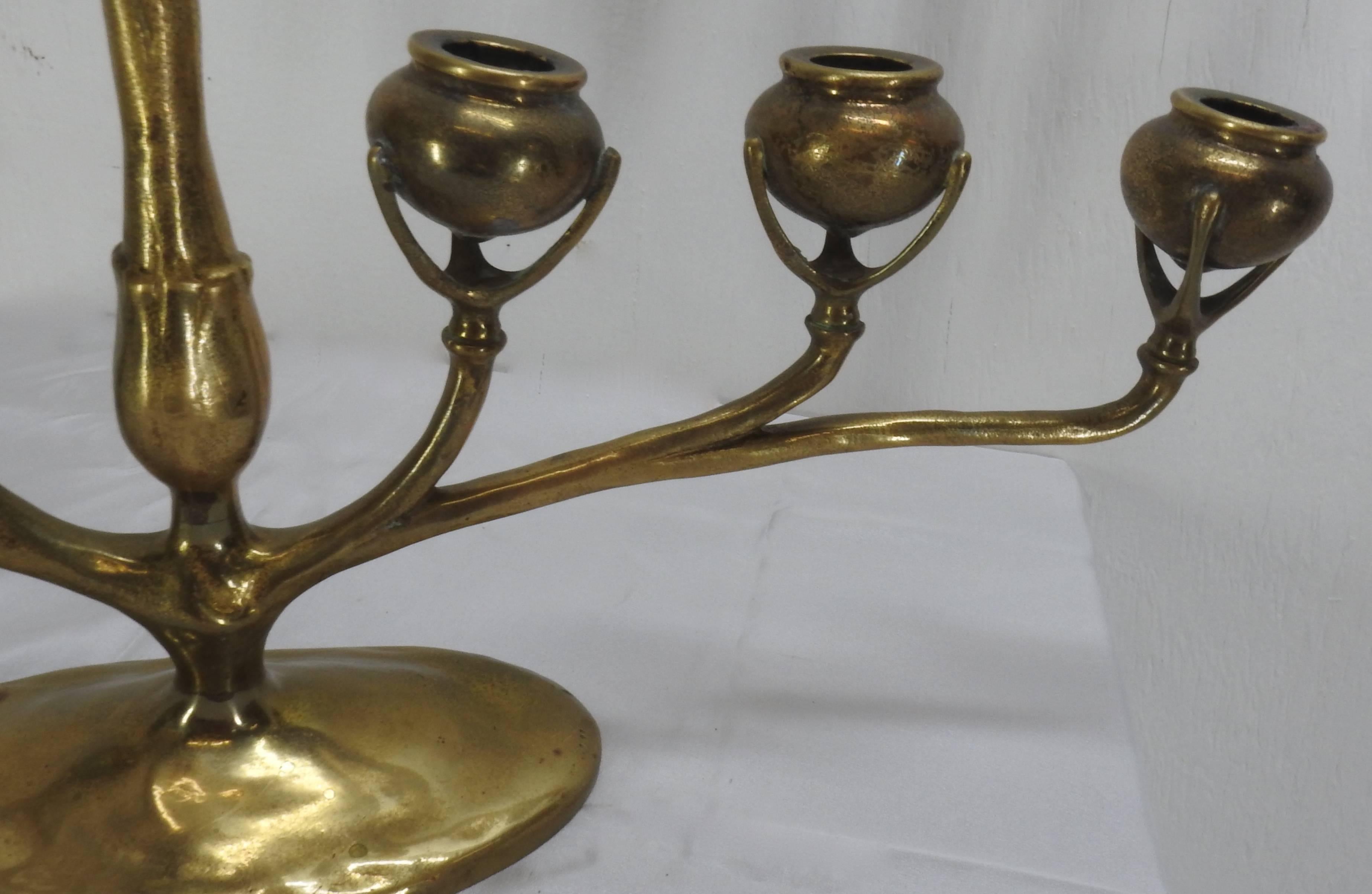A lovely Tiffany gilt bronze six-arm candelabra from the Art Nouveau period. Six candle sconces are raised on supports. Each piece is supported on branches that are attached to two arms, one on each side of the main stem, all raised on an elongated