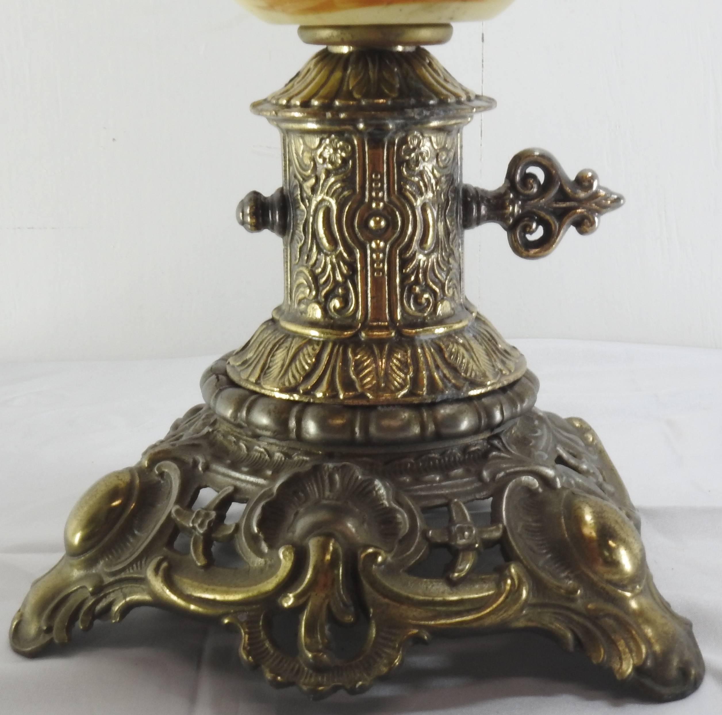 This listing features a fabulous hand painted jardinière depicting a fisherman on the water and magnificent mountains in the background. The antique brass finish cast metal surrounds the top and bottom and hosts a cherub on the top of the handle.