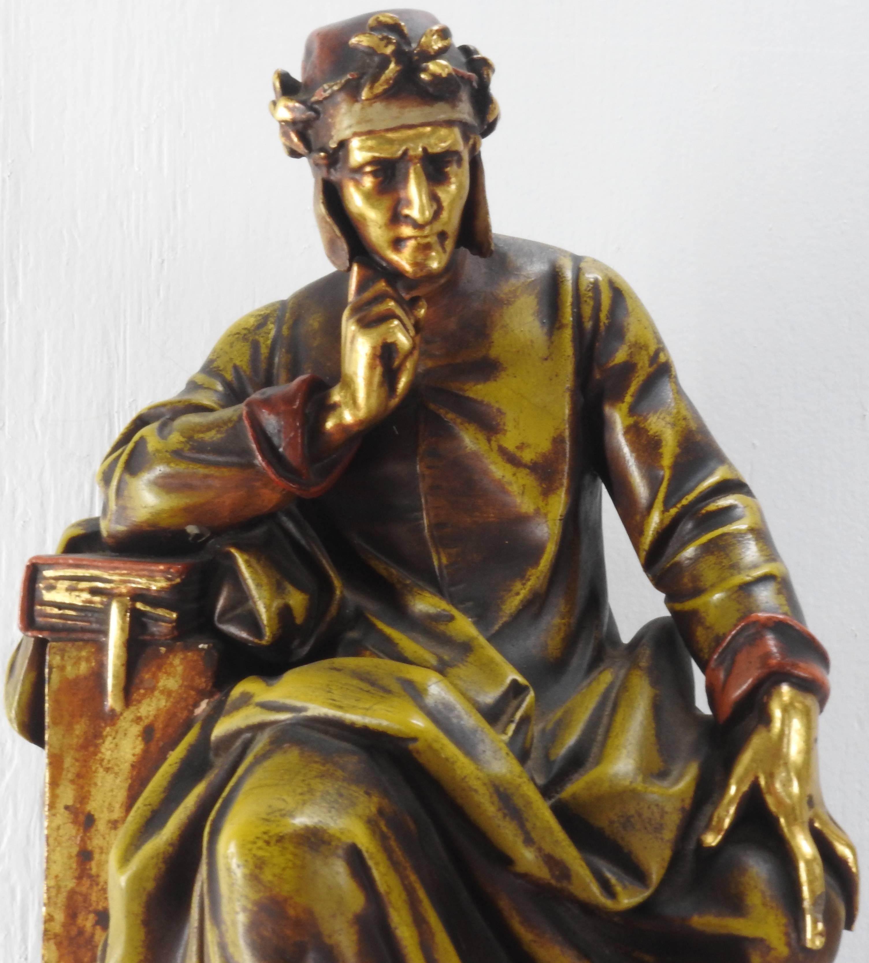 Shades of gold gilt and red decorate this Dante statue of a gentleman on a pedestal, perched on a book and he obviously has something on his mind. His flowing red cap is embellished with a ring of flowers. He is made of terracotta.
