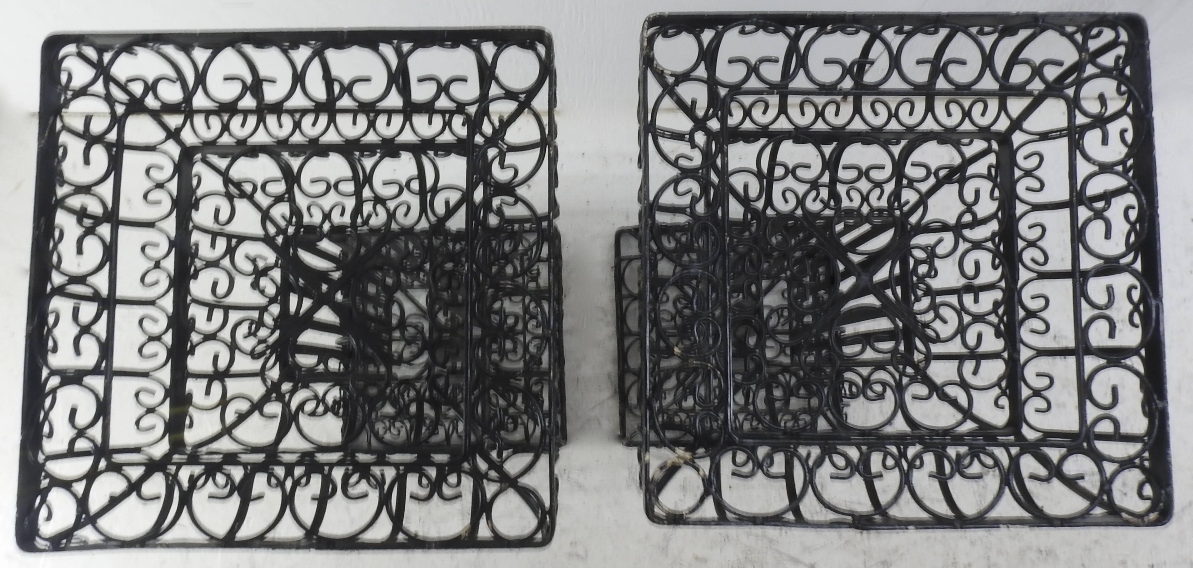 Featured is a pair of Victorian metal plant stands painted black. They feature swirls of metal to form the ornate details on the stands.