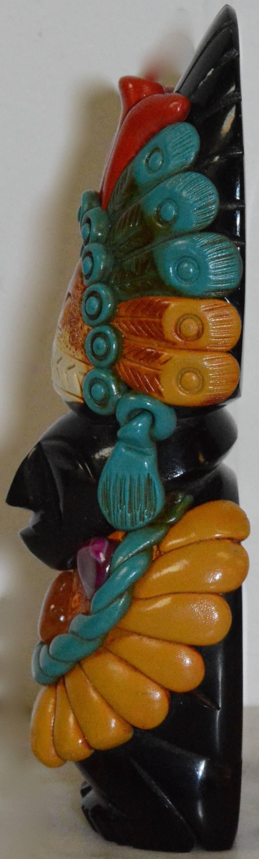 We are offering a carved stone statuette, embellished with stone and formed polymer accents. The statuette depicts a man with a carved face, which is made of black onyx. The figure is embellished with applied dyed quartz stones, and with embossed