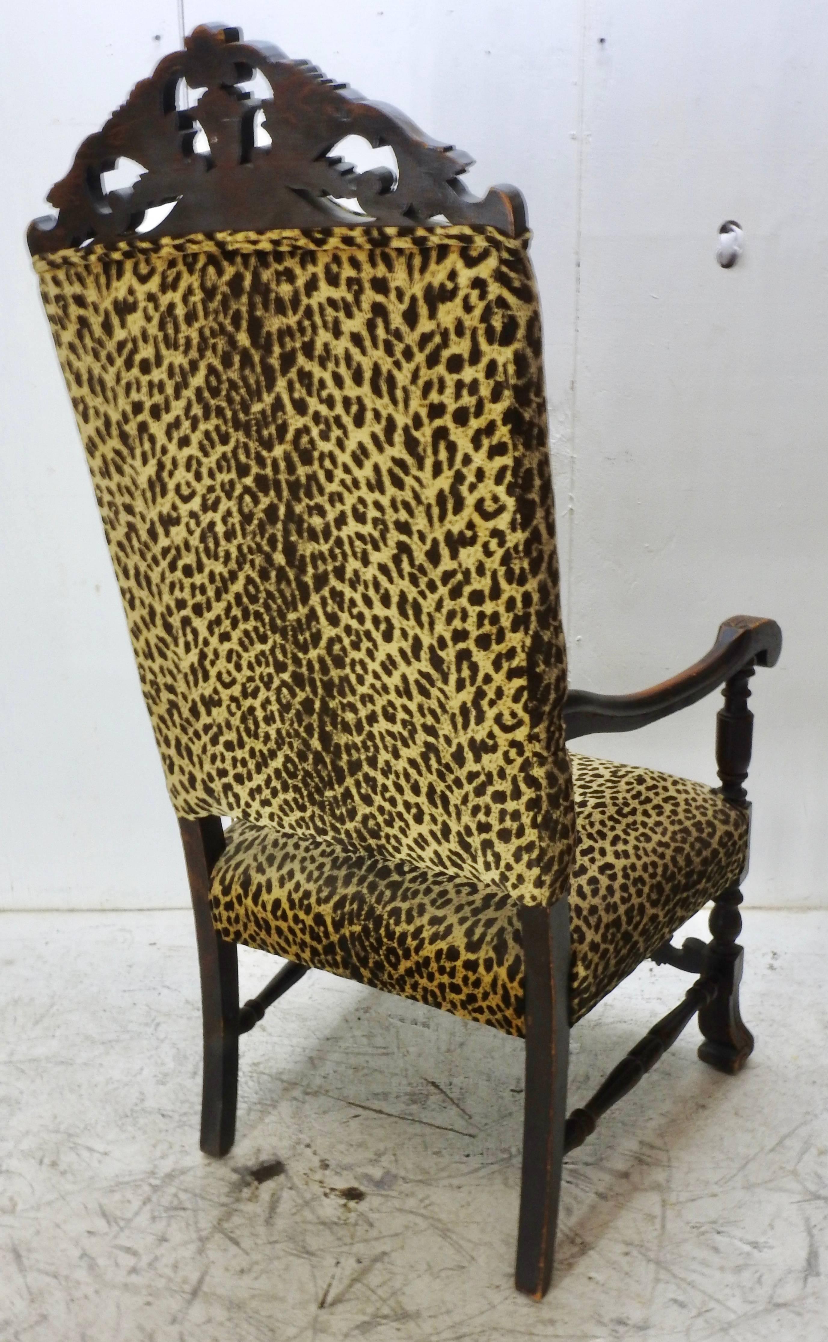 We offer this gorgeous German carved high back chair that is in a dark stained walnut. With intricate scroll work detail at the top and one as the front stretcher. Leopard print upholstery covers the seat and back of this chair and will make a great