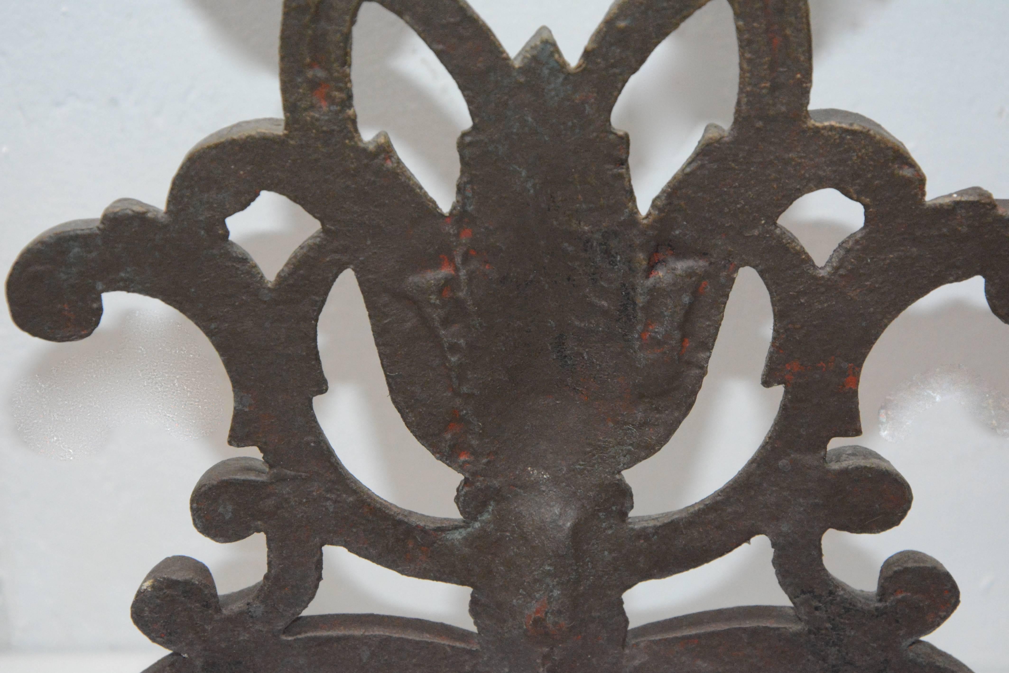 We are featuring a fabulous cast iron fireplace screen from the Victorian era. The piece is a darl brass tone in color and has an intricate slit design throughout with scrolled lines and scrolled feet along the base. It offers four hinged sections