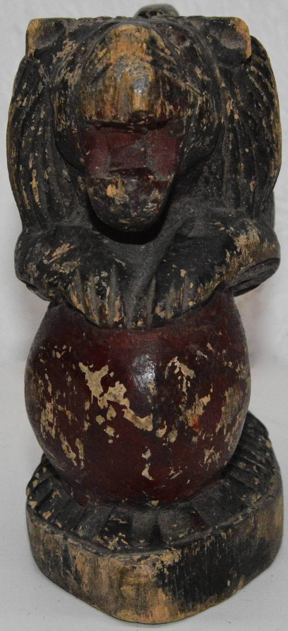 This is a unique early 19th century wooden carving depicting a stylized lion in black distressed paint, posed rampant on a red ball. Noticeable detailing to the lion’s mane, upturned tail and fluted oval base.