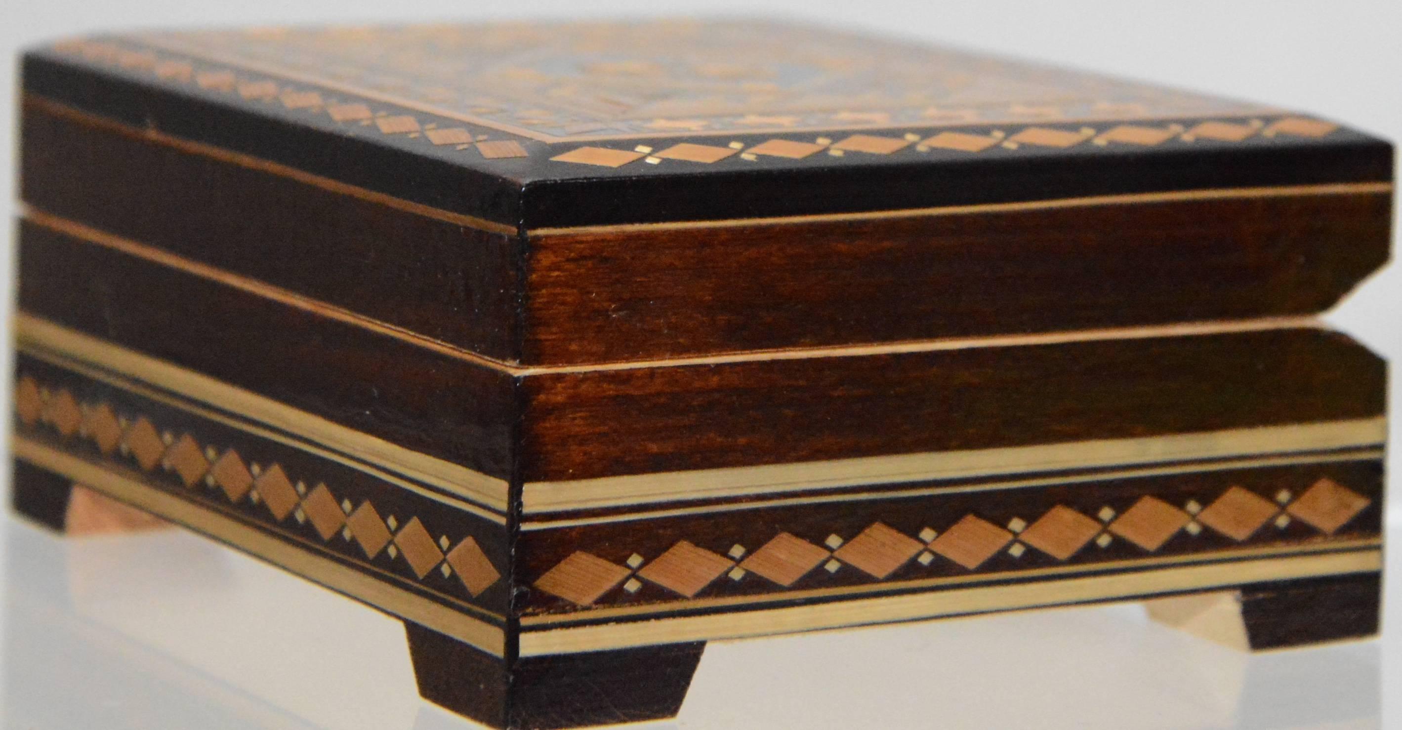 The intricate design on our box will grab your attention. Great details have been formed out of different shades of wood to make this a beautiful keepsake. The hinged lid opens to plush black lining.