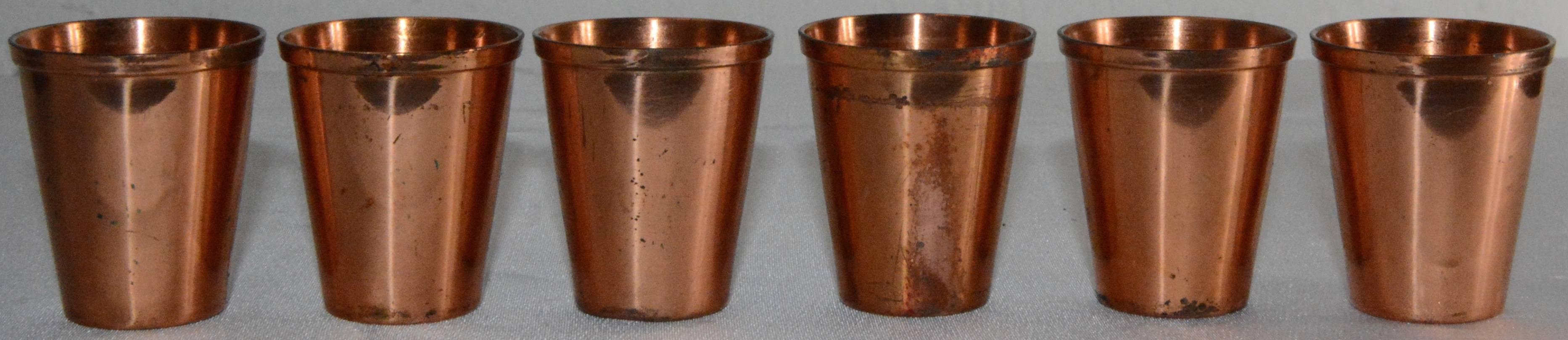 This is an interesting set of copper shot glasses with a unique leather case by West Bend. This set of six shot glasses are simple in design with tapered form and slight ridged rim. Each shot glass is stamped “Solid Copper WB” to the underside. The