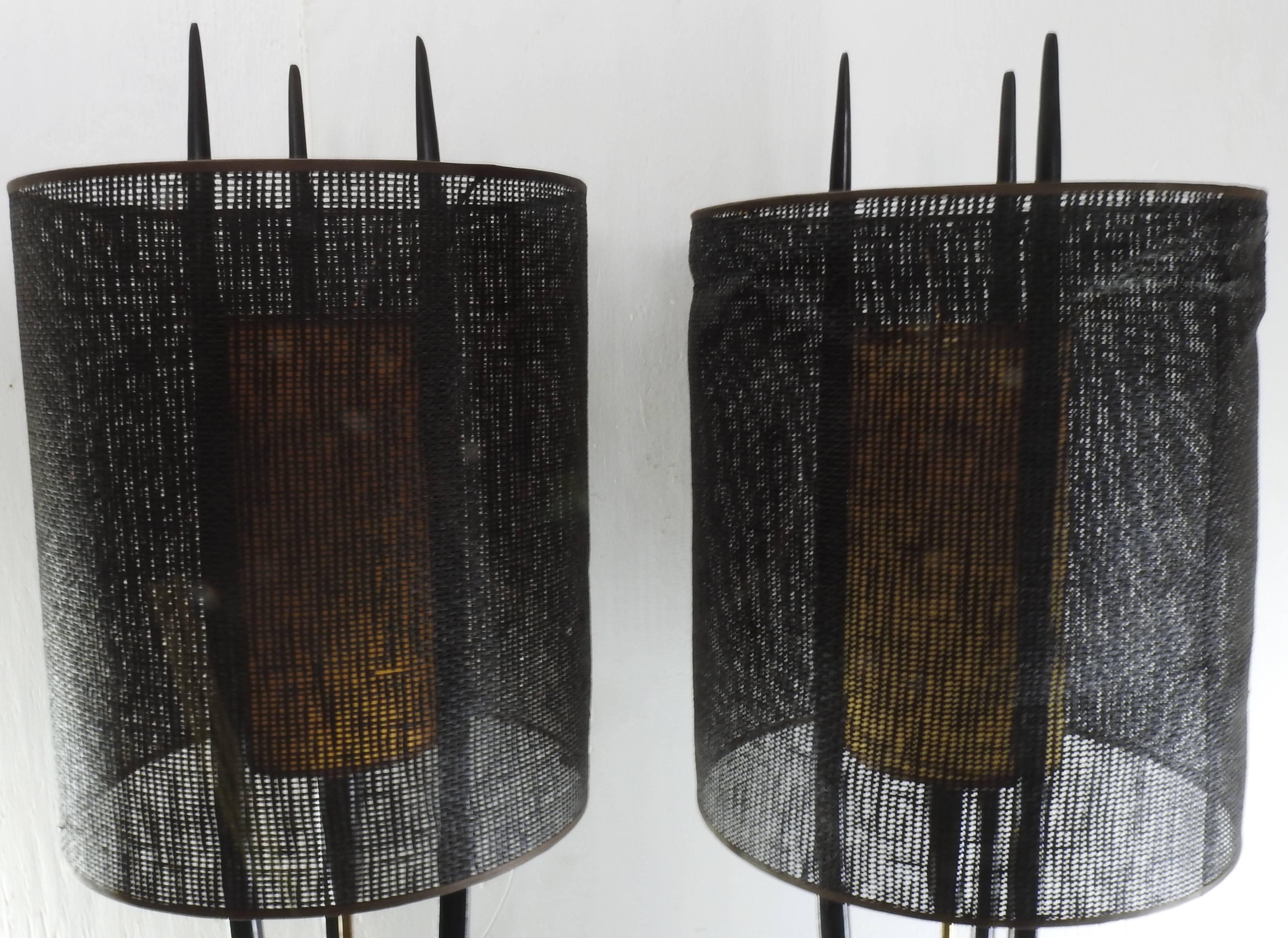 This is a Classic pair of vintage Danish Modern Modeline Rocket table lamps. Lamps feature an ebonized finish, with secondary inner parchment shade, and outer open weave drum shade and center pull. The shade is mounted to three teak batons. These