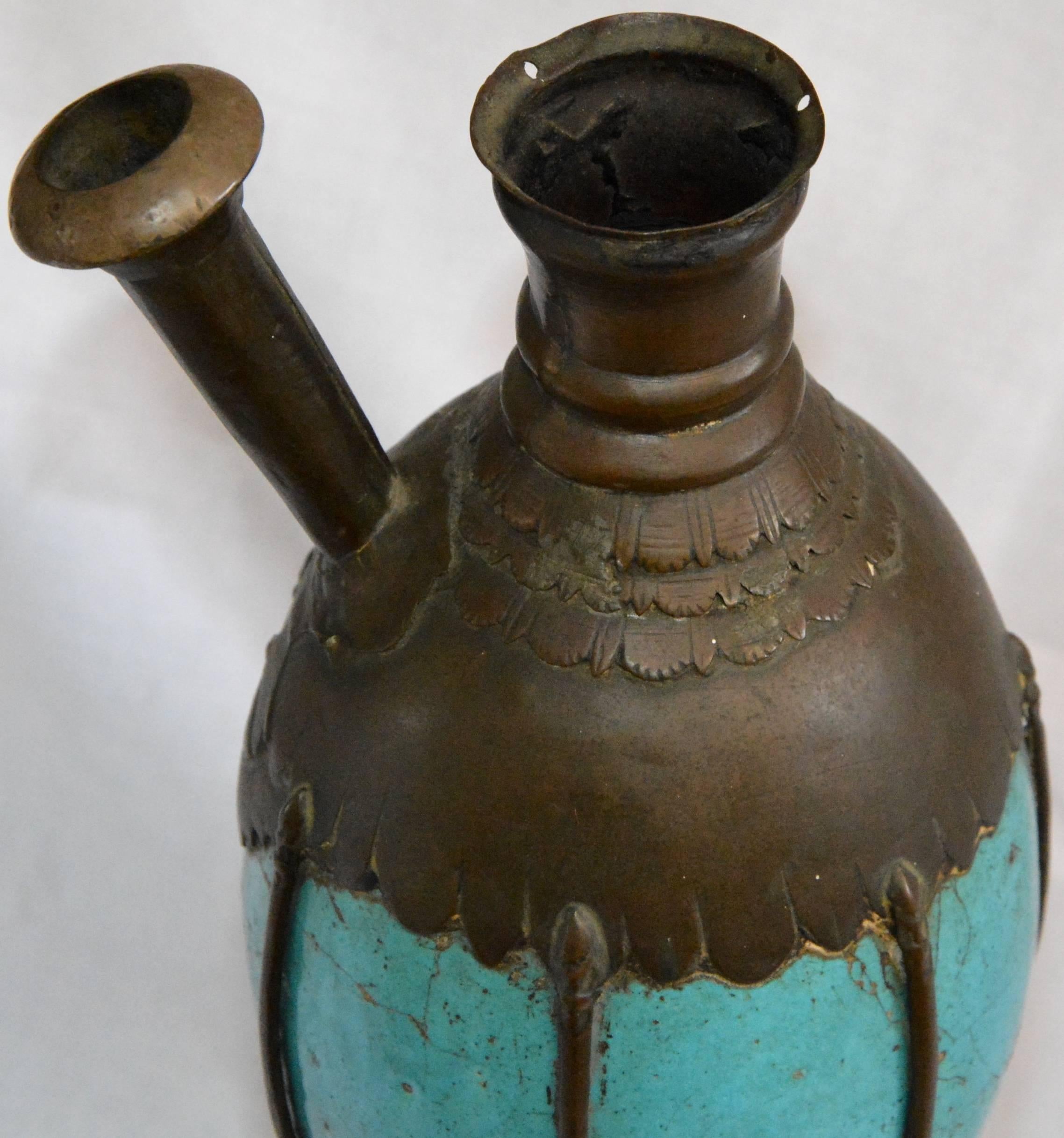 Featured is an ornate antique hookah. The hookah features a bronze metal body with a curved footed base and a turquoise blue ceramic center. The metal work has great details. This item is unmarked. It does not include a hose or bowl.