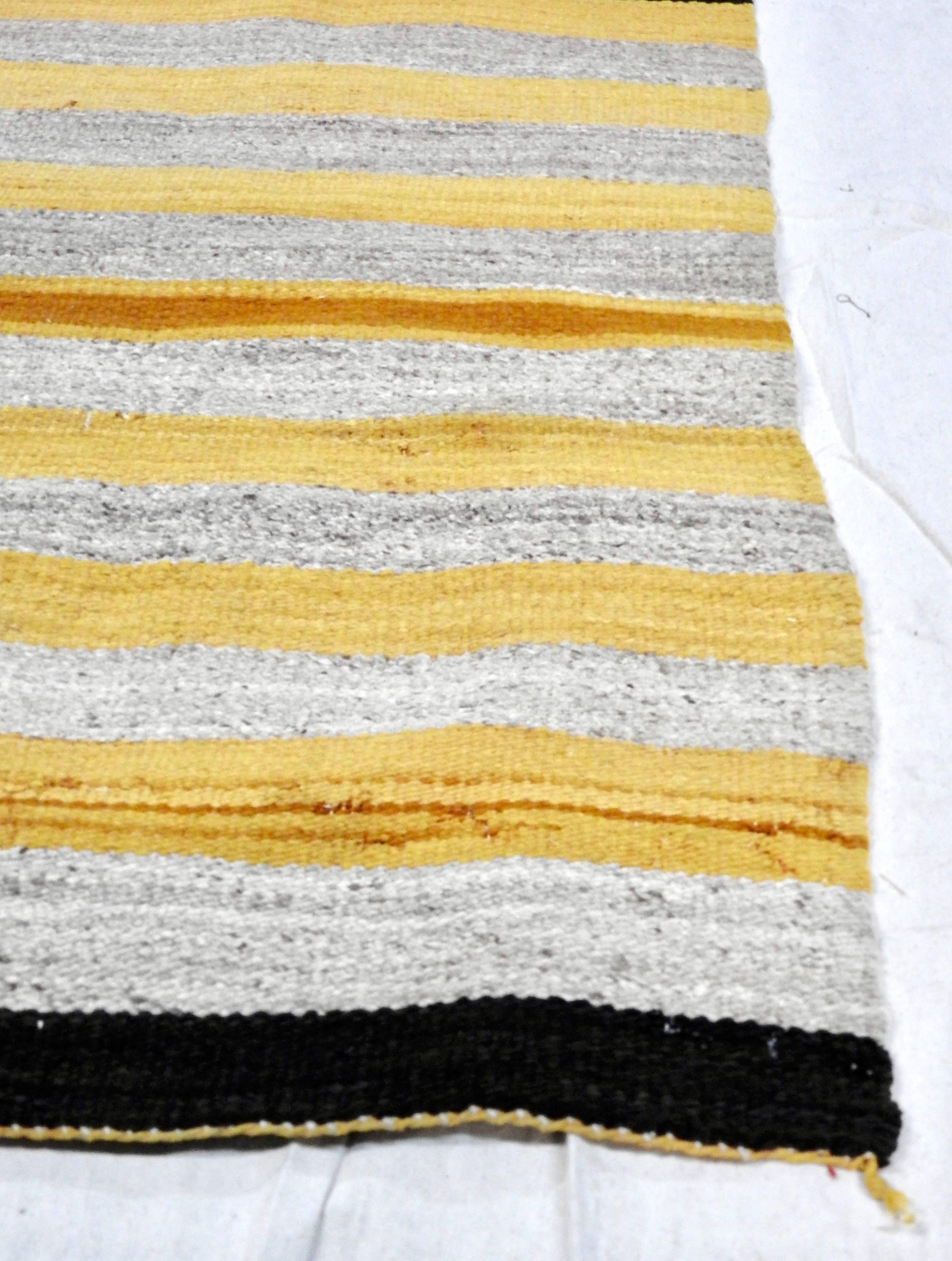 This is a nice, regional Navajo weaving in gold and natural heathered taupe stripes with dark brown borders at each end, circa 1950. The gold stripes show some variations and there are subtle variations to the taupe stripes as well.