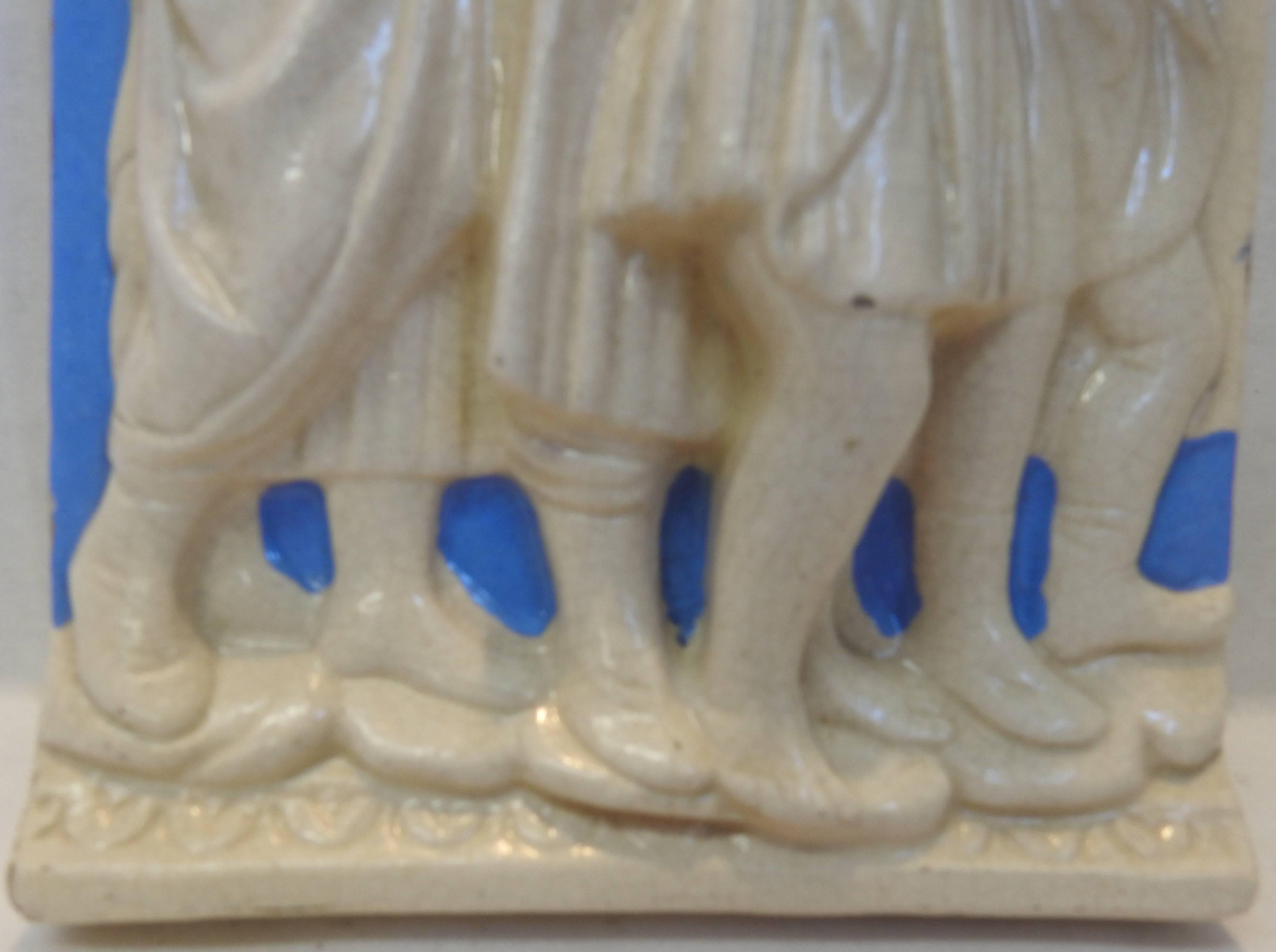 This listing features a high relief Della Robbia polychrome glazed pottery plaque that was made in Italy. It has a group of choir boys singing from a hymnal in their Classic blue and white glaze. It is marked on the back with a signature and Italy.