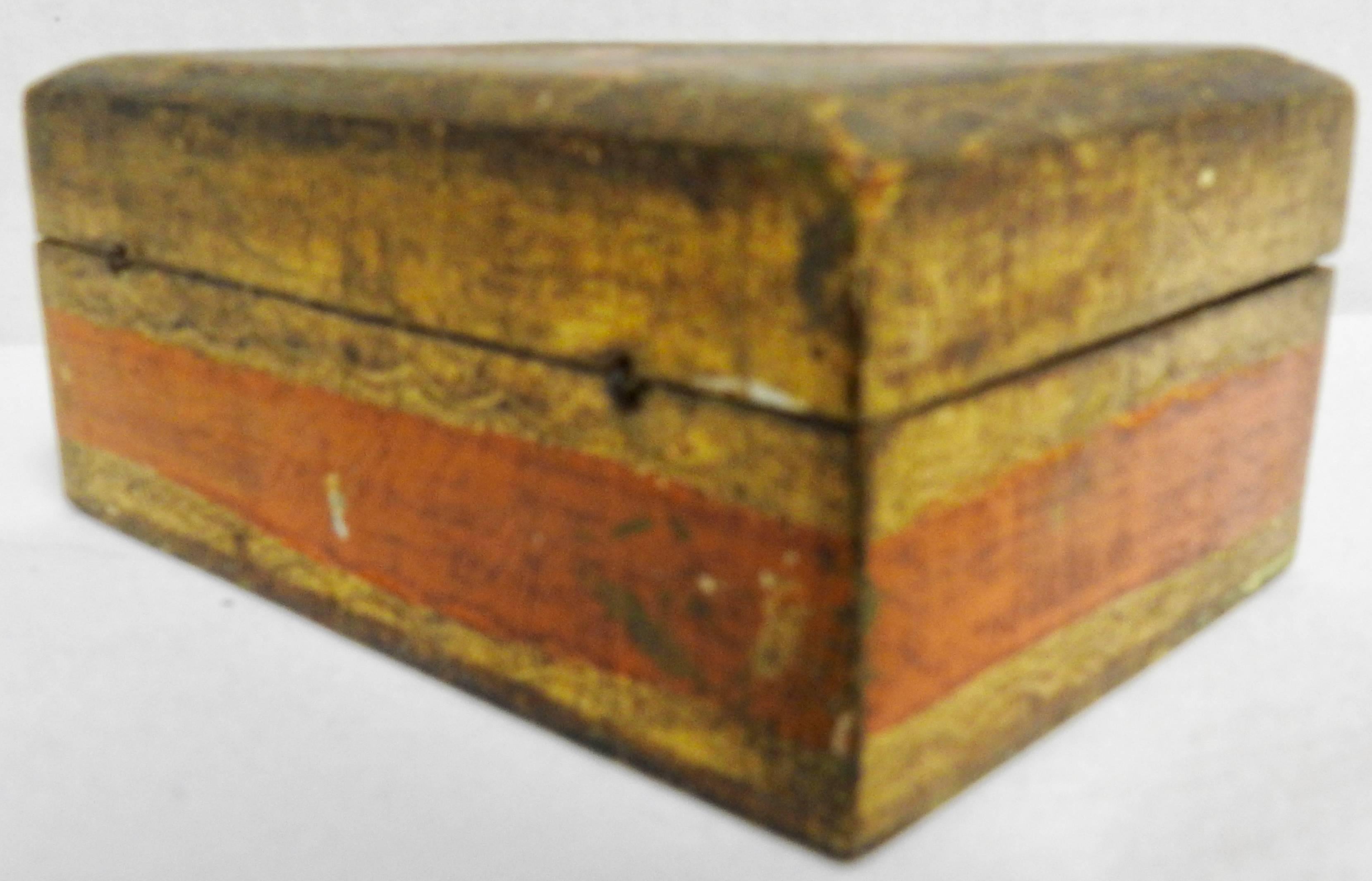 Featured is a small Florentine box from Italy, made during the mid-20th century. It is decorated with gilt along with detailed tangerine orange and a touch of emerald green. The inside is finished in a soft yellow. Tiny wires serve as the hinges.