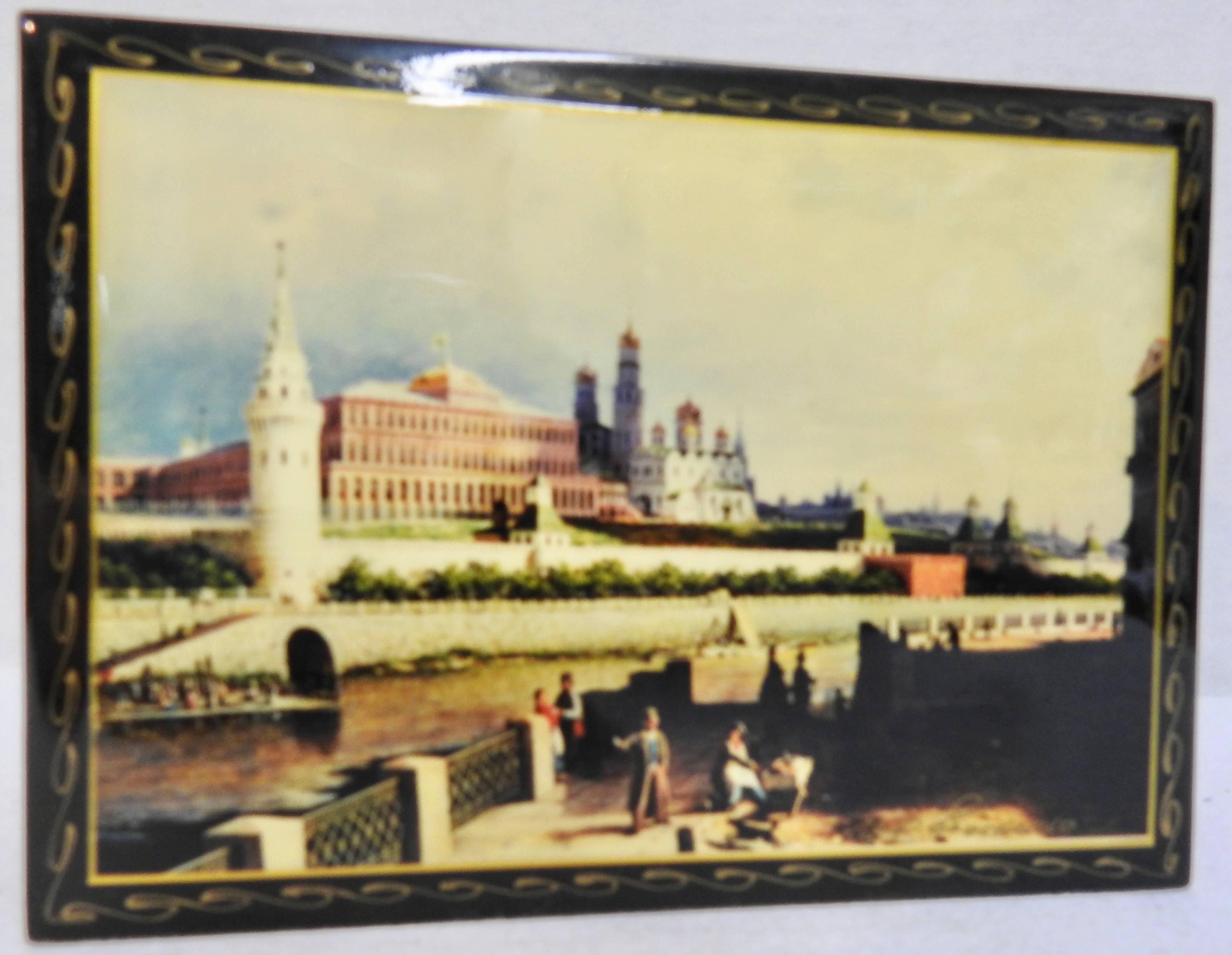 The Kremlin including the buildings with onion domes, are in the background of the waterfront scene on this Russian black lacquer box. People are enjoying the peacefulness of the water. Waves of gold surround the edges of the box. It opens to a