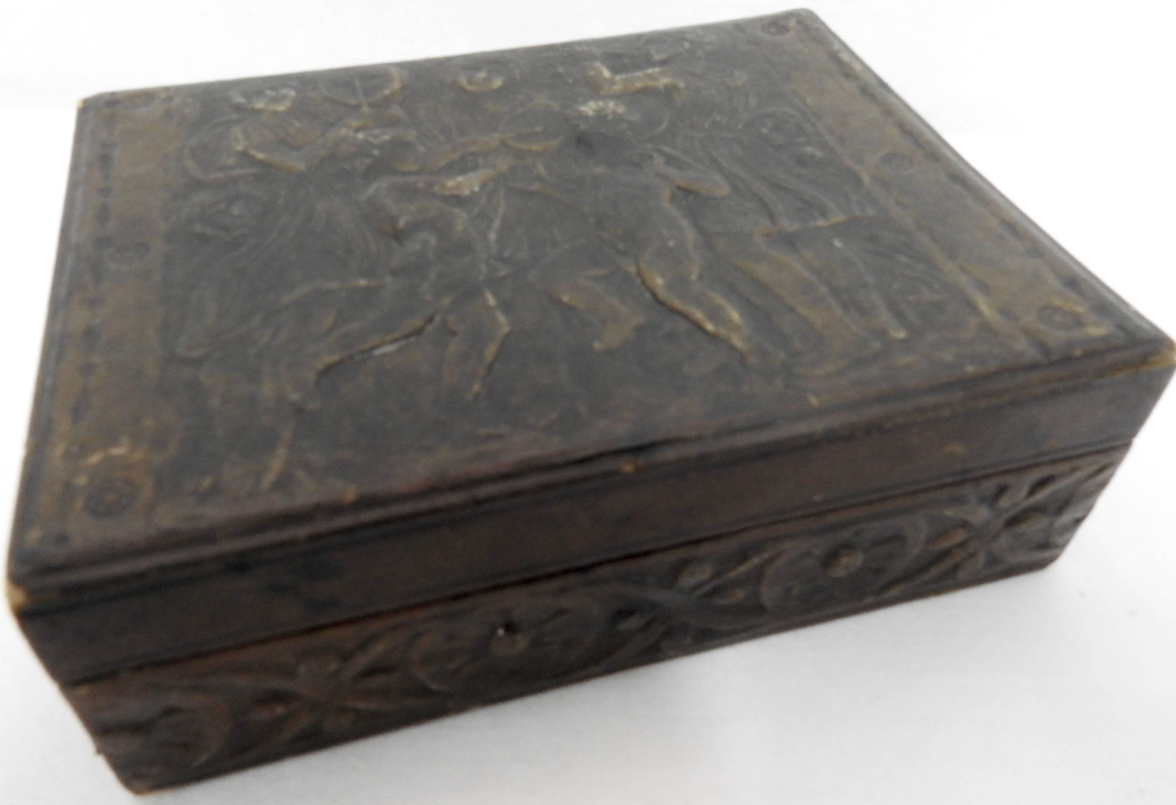 Dancers and musicians decorate the top of this detailed leather box from the Art Deco. It was created in Italy as you can see from the stamp on the back. A lovely floral motif surrounds the sides of the box. The inside is lined in a stiff paper.