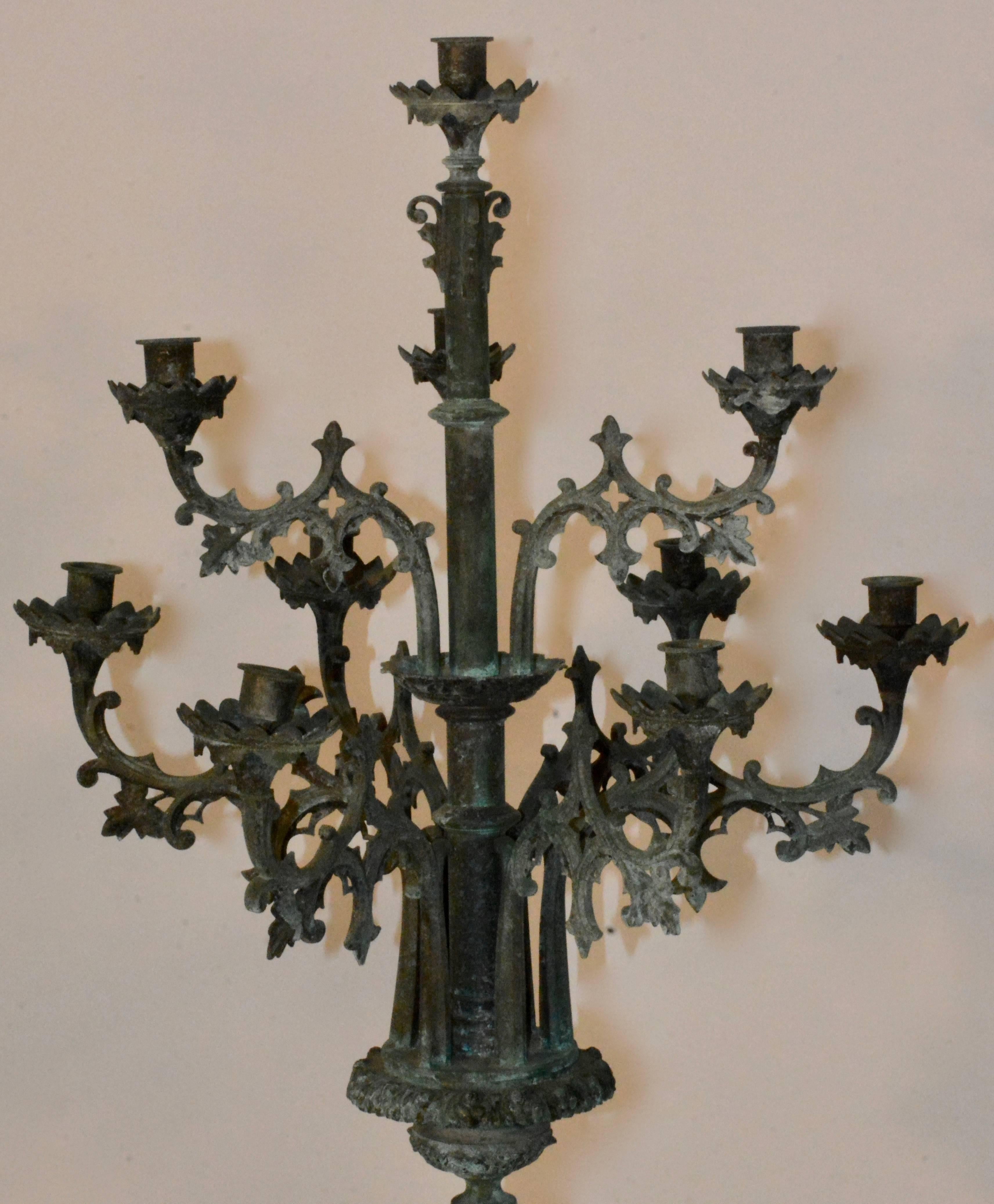 Featured is a stunning pair of 19th century French bronze standing candelabras. These gorgeous patinated bronze candelabras stand on a beautiful bases. Both have ten scrolled arms with intricate detailing and cut-outs.