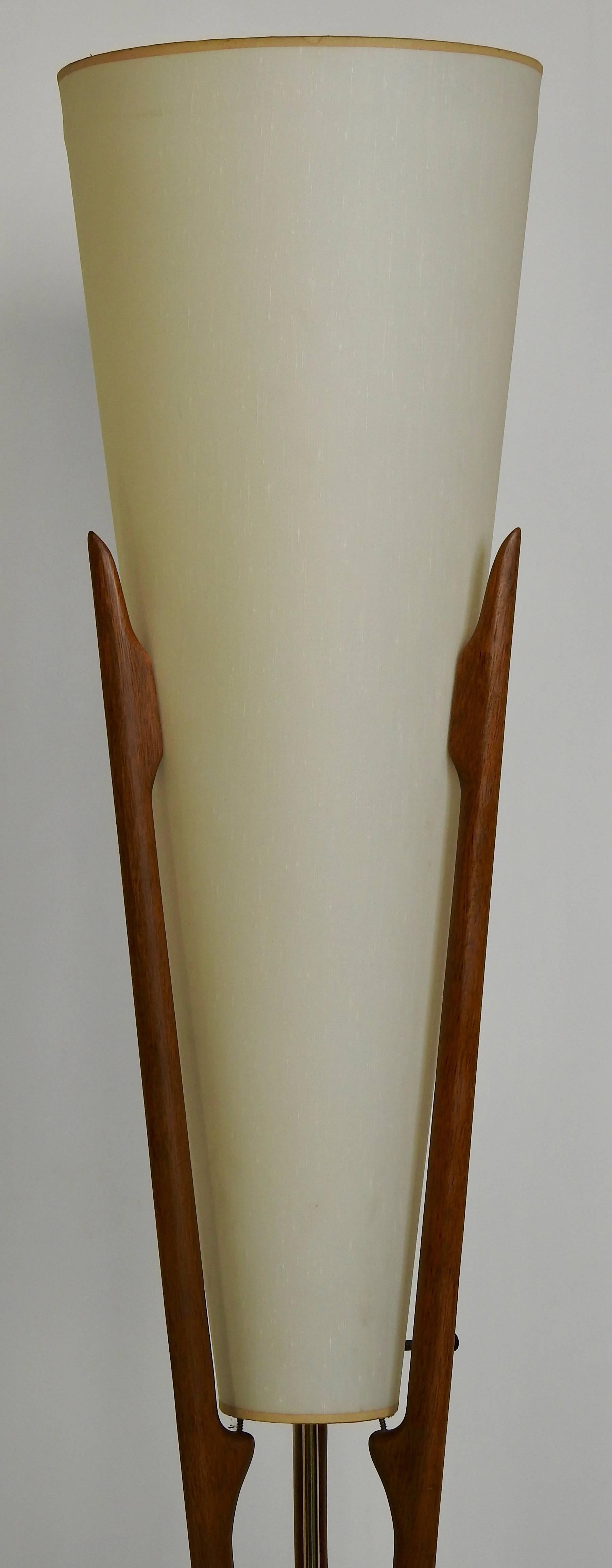 Featured is a Mid-Century Modern lamp by famed furniture designer Adrian Pearsall (1925-2011). This lamp is in very good condition with beautiful lines. It has the original shade and is made of walnut. Brass detailing accents the piece. The lamp has