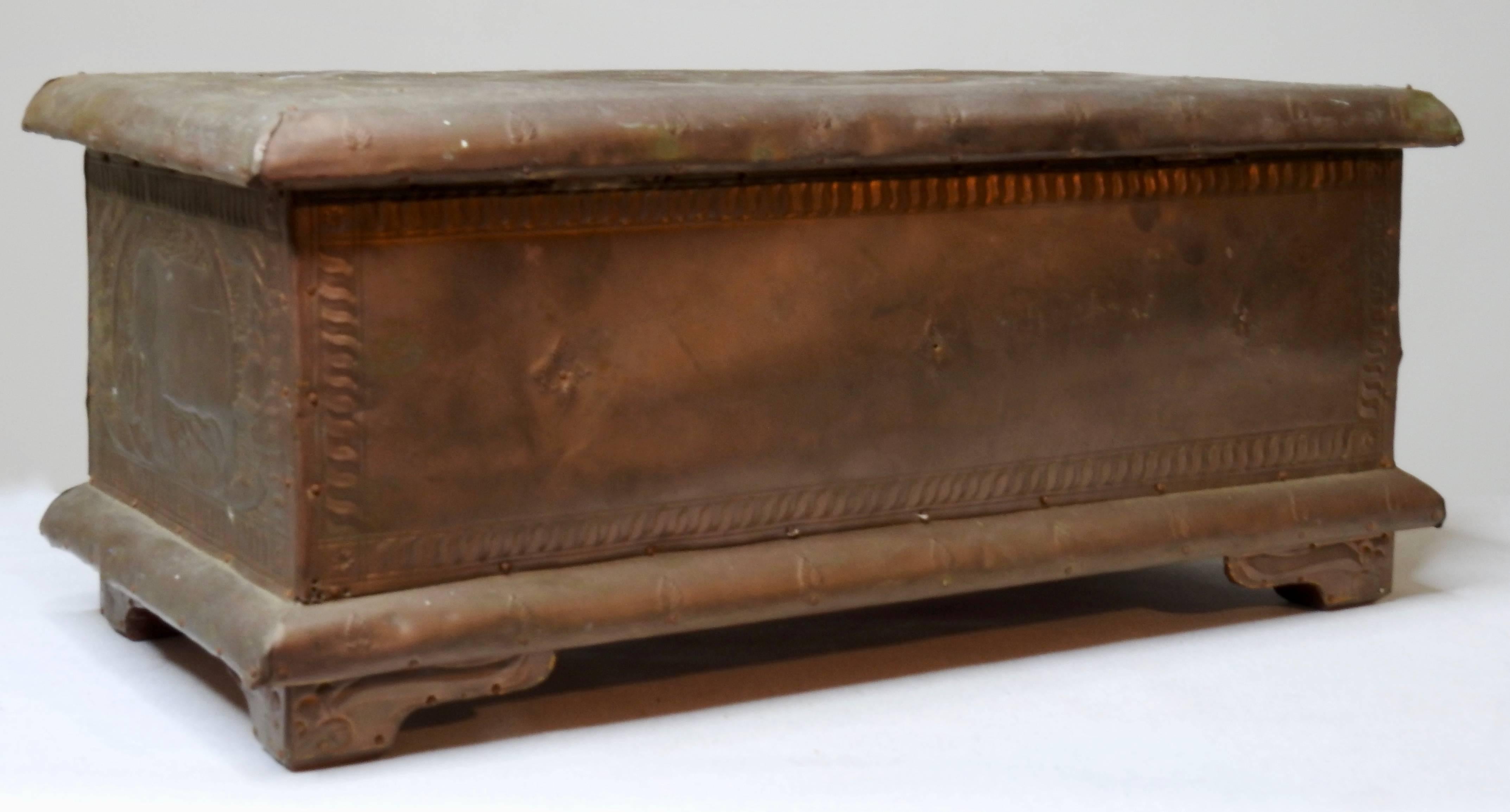 This cherrywood box is covered in a pressed copper with animal figures and foliate detailing. When open the box shows its beautiful warm toned wood with a compartment to the right side. The box has the original key.