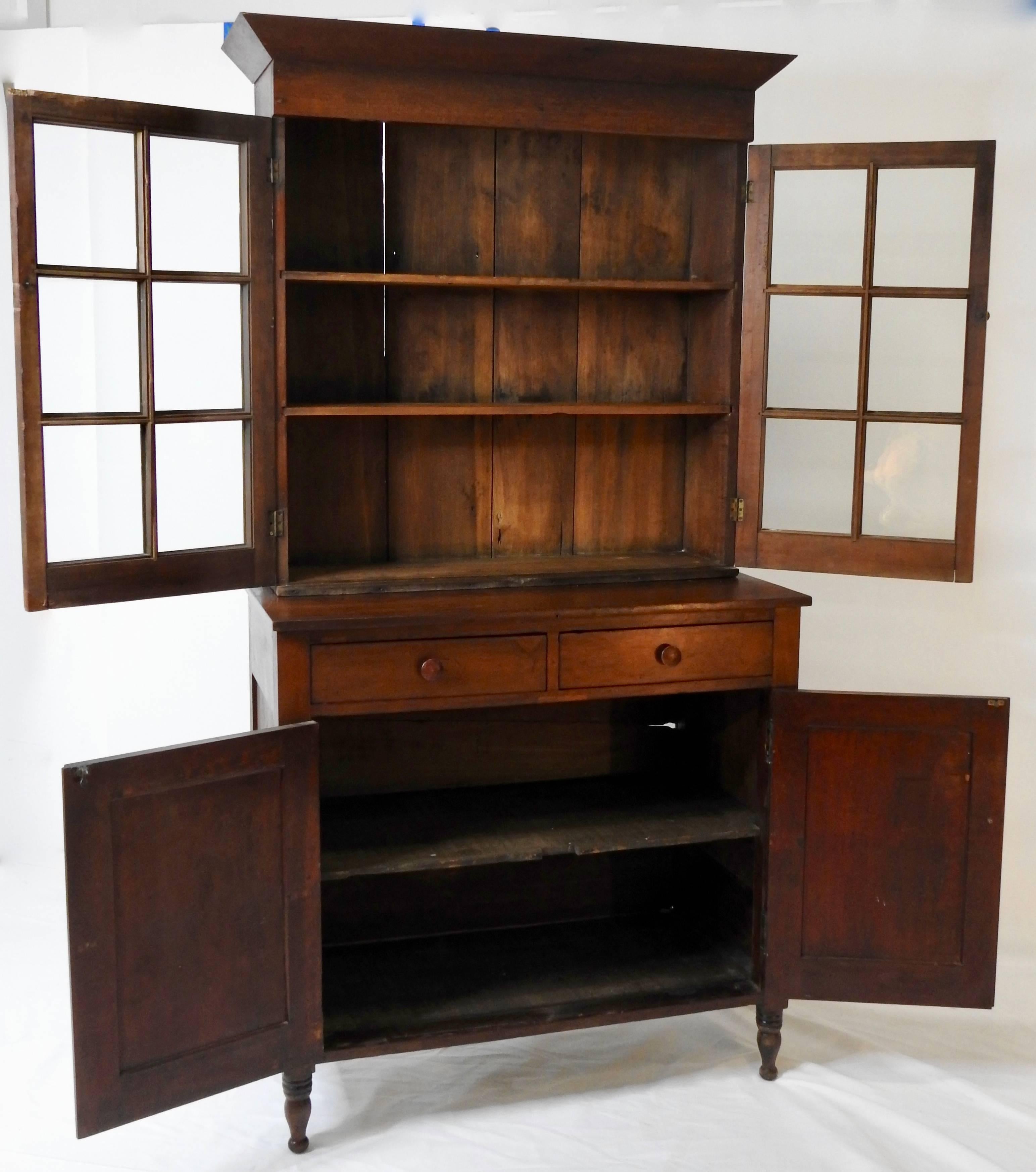 This is a stunning Cherry Jackson press from the east Tennessee area. It features the original glazed glass with bubbles. The drawers are dovetailed and it boasts Classic turned feet. There are three shelves inside the top and two in the bottom. It