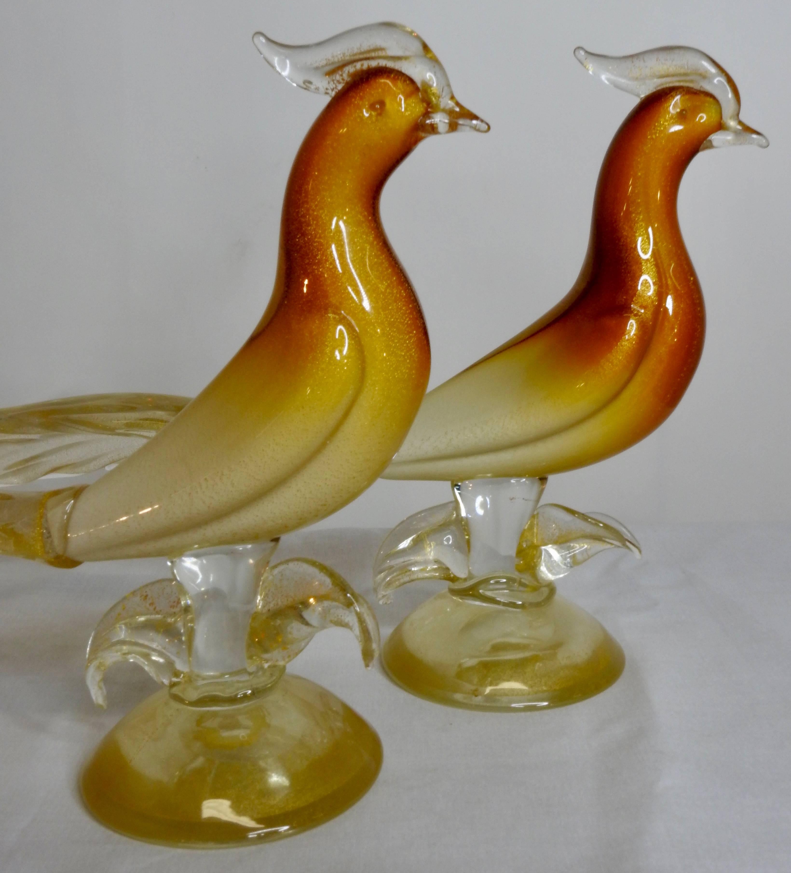 Pair of Salviati & Co. Murano glass pheasants. These beautiful birds are done in brilliant amber, gold and white tones. The pair are perched on top of round bases with foliate detail. Rising next to the body of the birds which have a white under