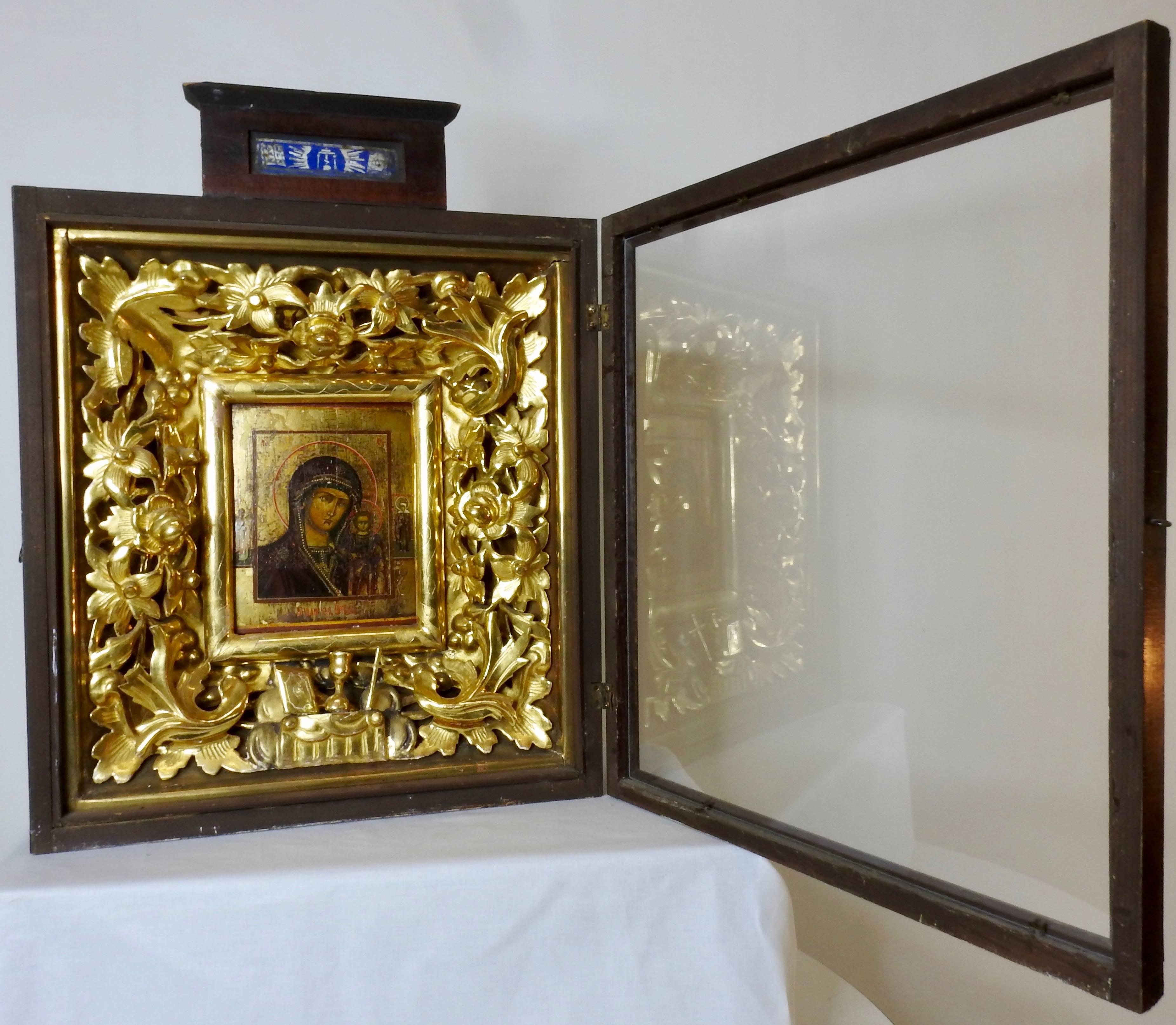 Rare Russian Religious icon from the 19th century. Framed inside a shadowbox made of veneered mahogany. Elaborate carved giltwood surrounds the painting of a saint with a child. Features flowers and leaves in an elaborate design. Painting is done on