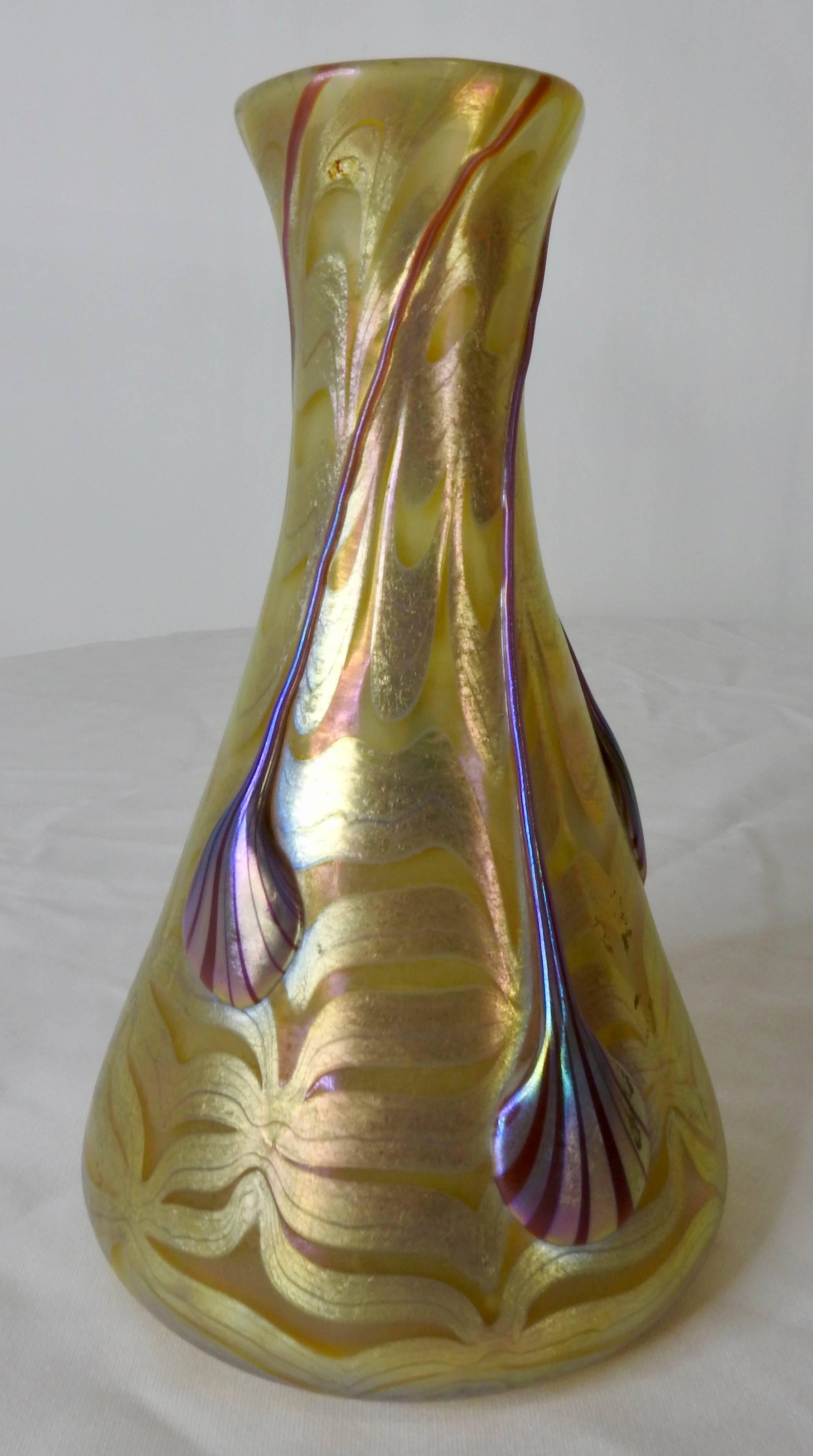 This is an outstanding Loetz Phaenomen genres vase made in Austria. The glass is opal ground and combed with silver-yellow threads. Drops of red with striped metallic extend from top to bottom and are of differing lengths. The vase is signed Loetz