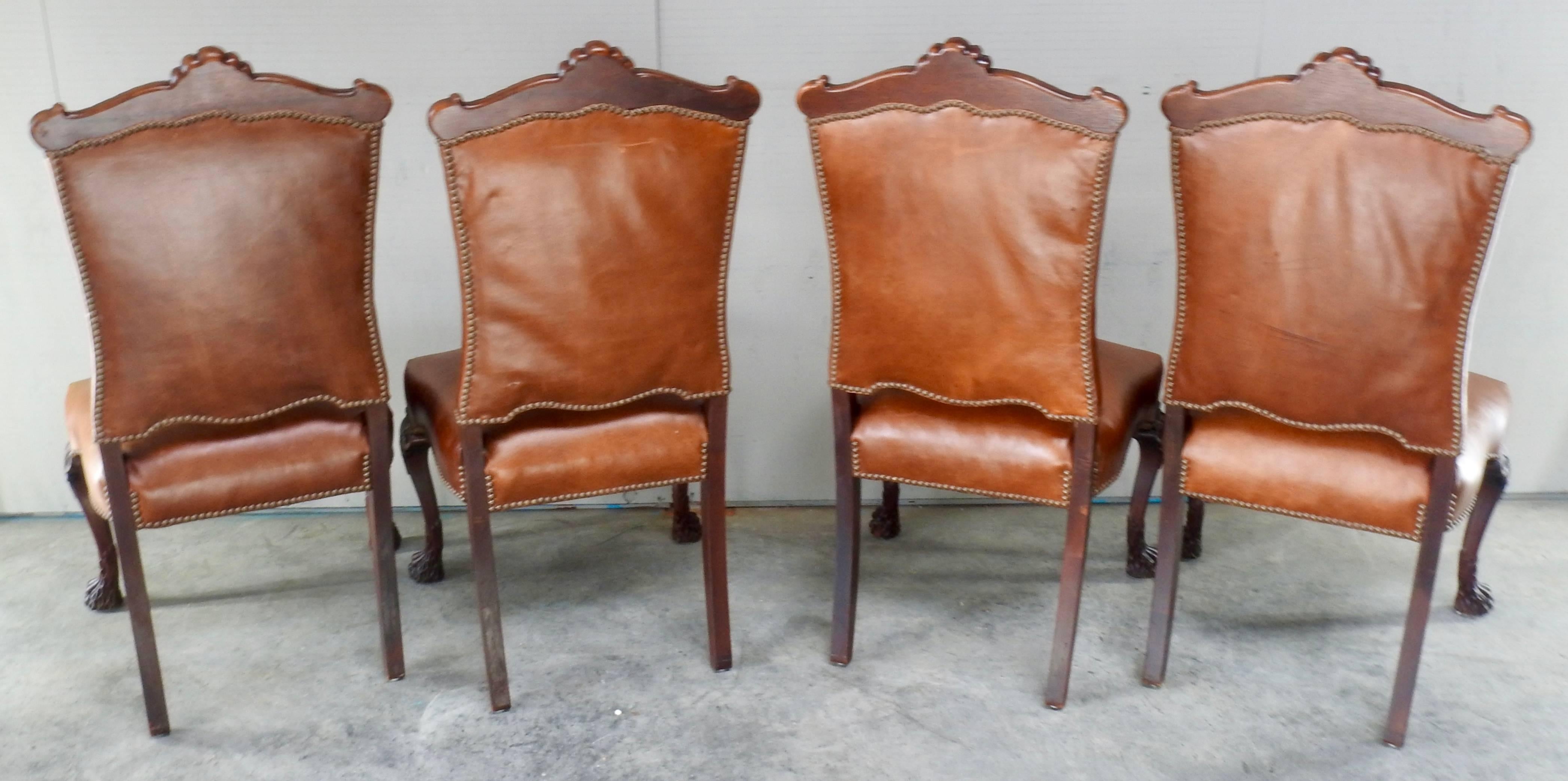Walnut with leather make up this set of four chairs with Hairy Paw feet. Accented with bronze tacks along the edges. Elegant fan with scrollwork accent the top of each chair.