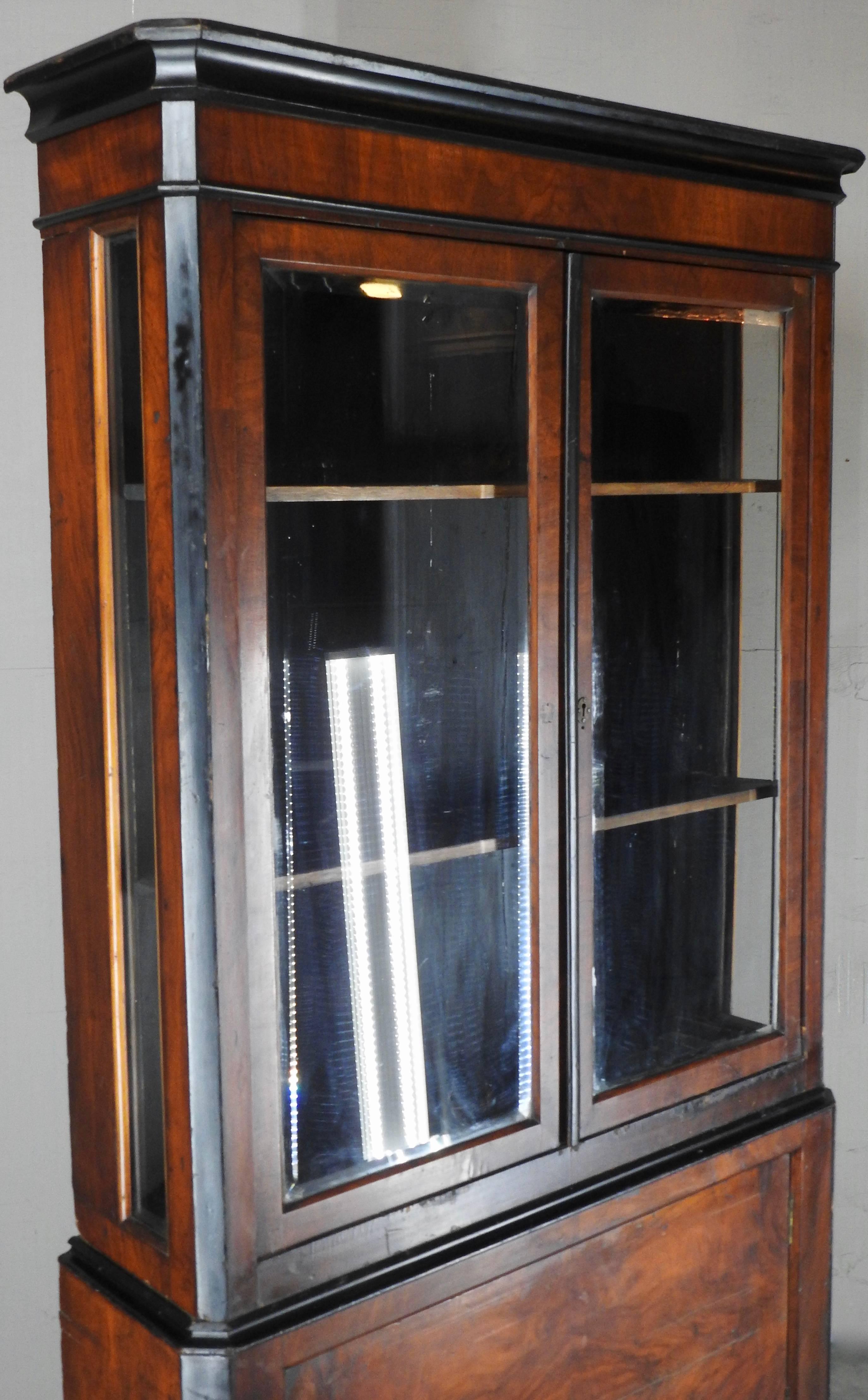 Burled walnut veneer forms this Biedermeier Bookcase from Germany. Two doors with glass open up to shelving. The bottom door opens for ample storage.
Angled lines make up the corners. This piece is from the 1930s.
