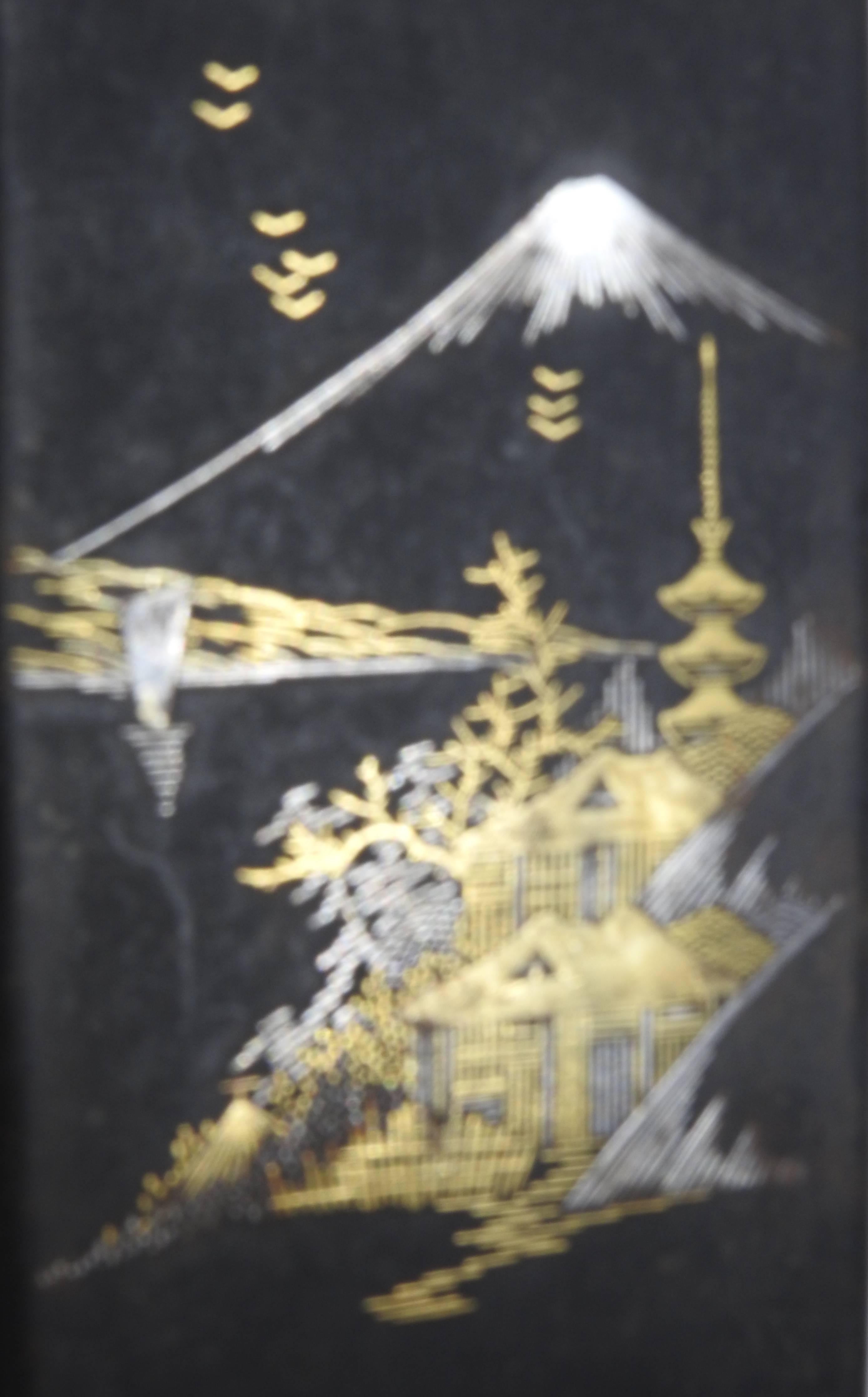 This is an elegant black finish over metal cigarette case and is adorned with an Asian mountain scene. The stunning case features the accents made of inlaid 18-karat gold and white gold which has been tested.