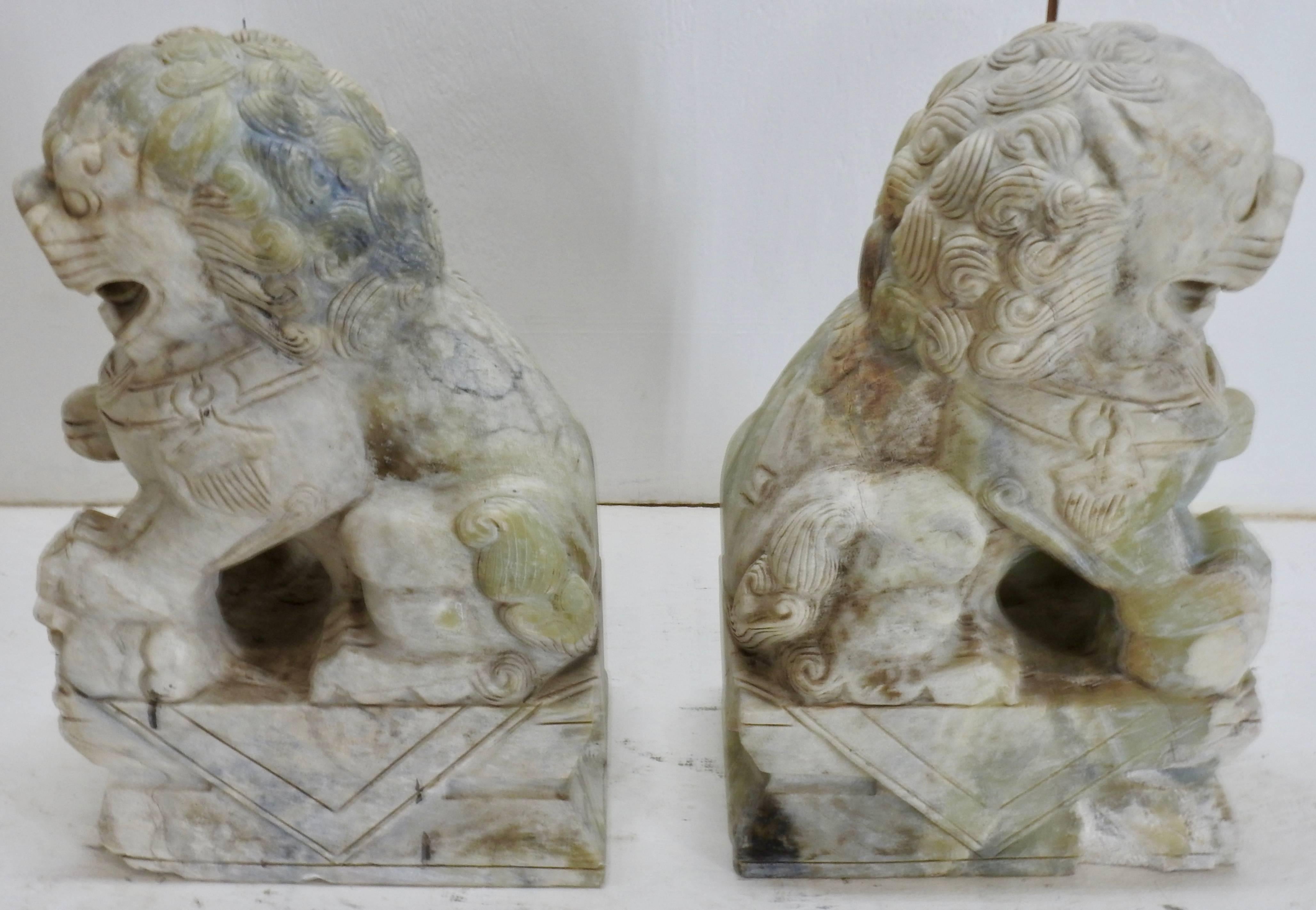An elegant pair of Tibetan guardian foo dogs made of alabaster. Their fierce grins will be a unique addition to your collection. The detailed carving on these are very nice!