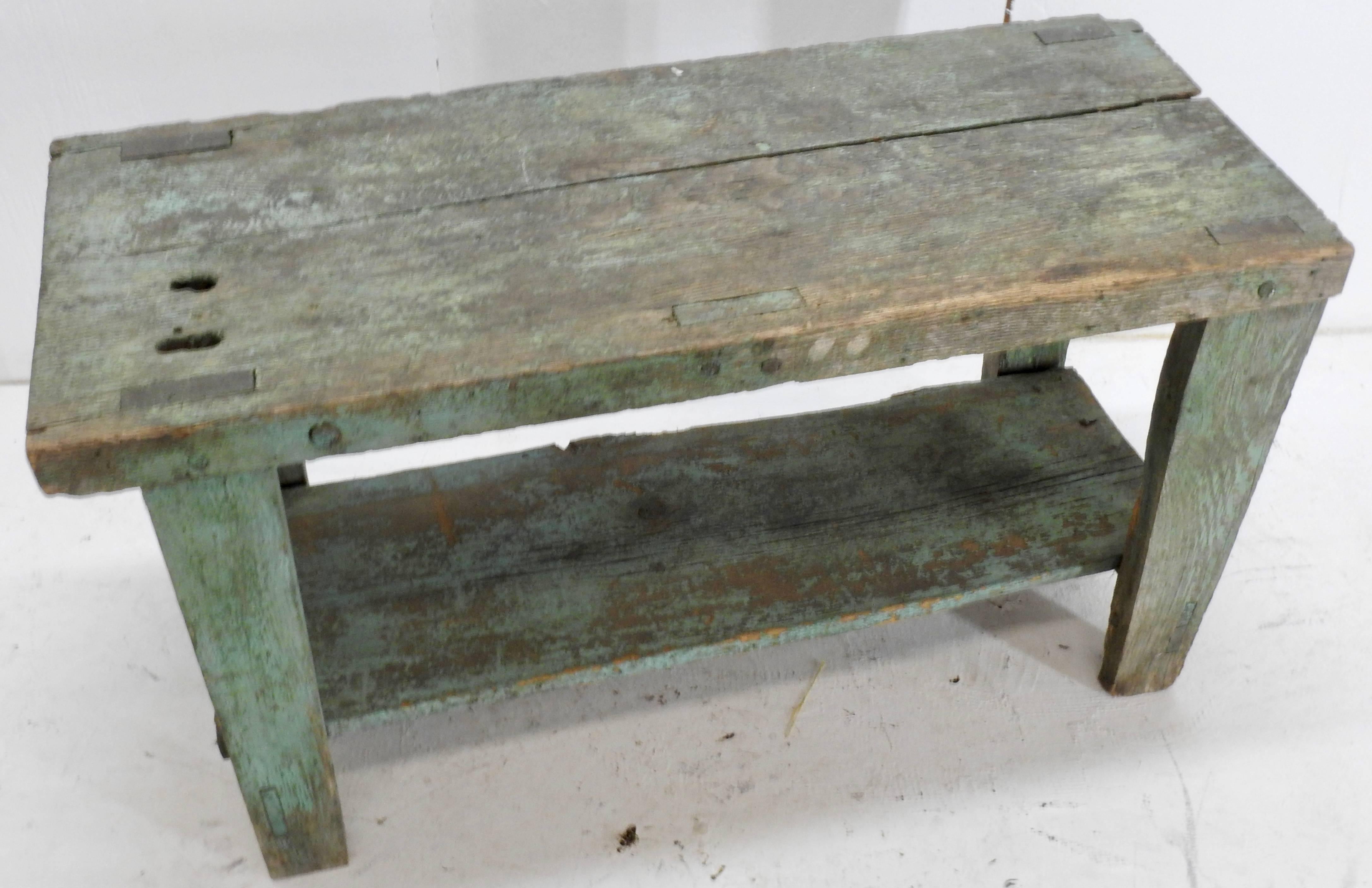 This is a rustic, primitive wooden bench featuring wood with a nice turquoise green aged patina. Has a lot of character to accent your home. The wear to the table makes you wonder about its history!