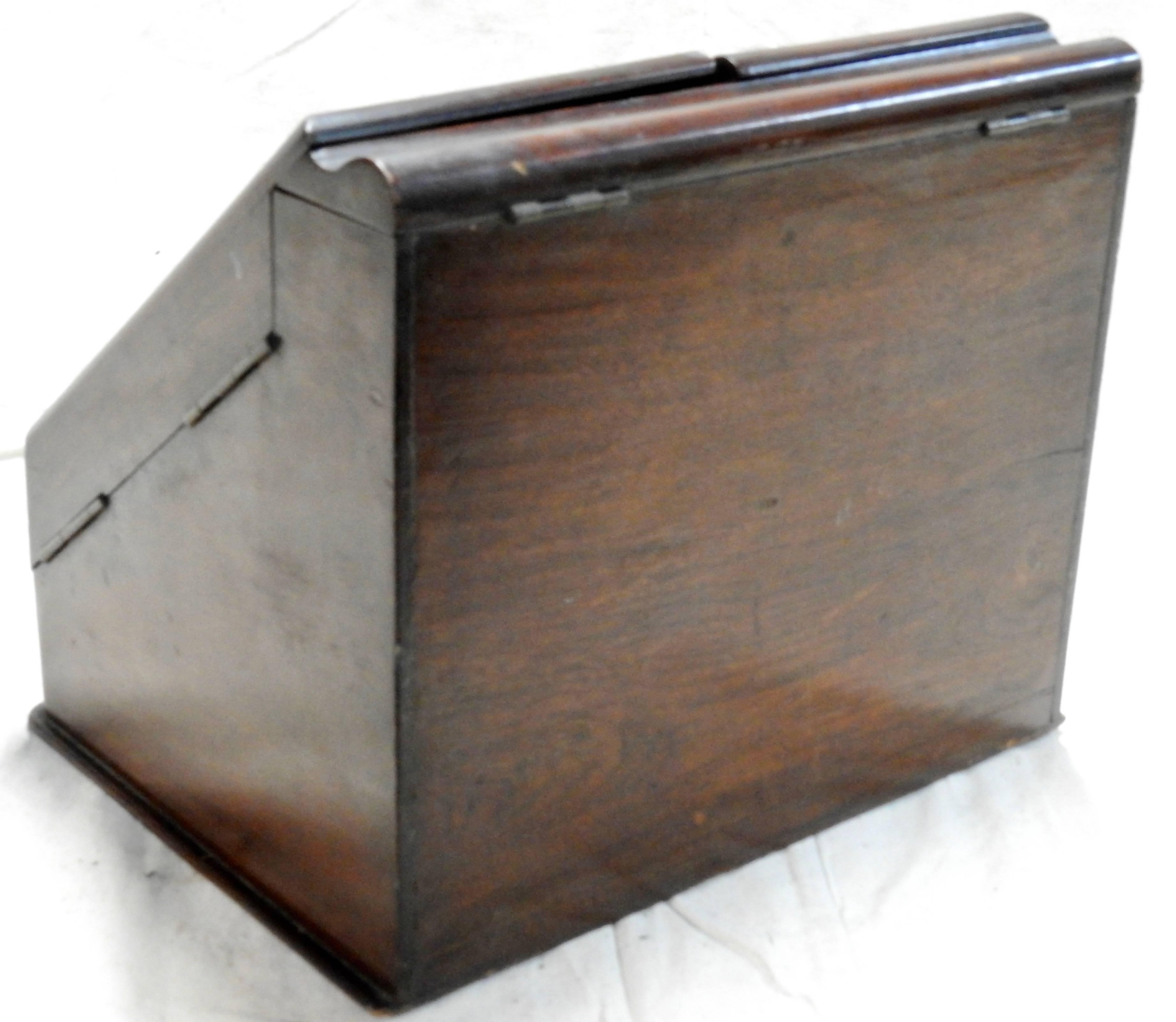 This walnut desk organizer is full of hidden compartments. It was made in England in the early 20th century. The top panels open to an assortment of compartments for organizing your paper goods. A hidden drawer opens on the bottom. The curved tray
