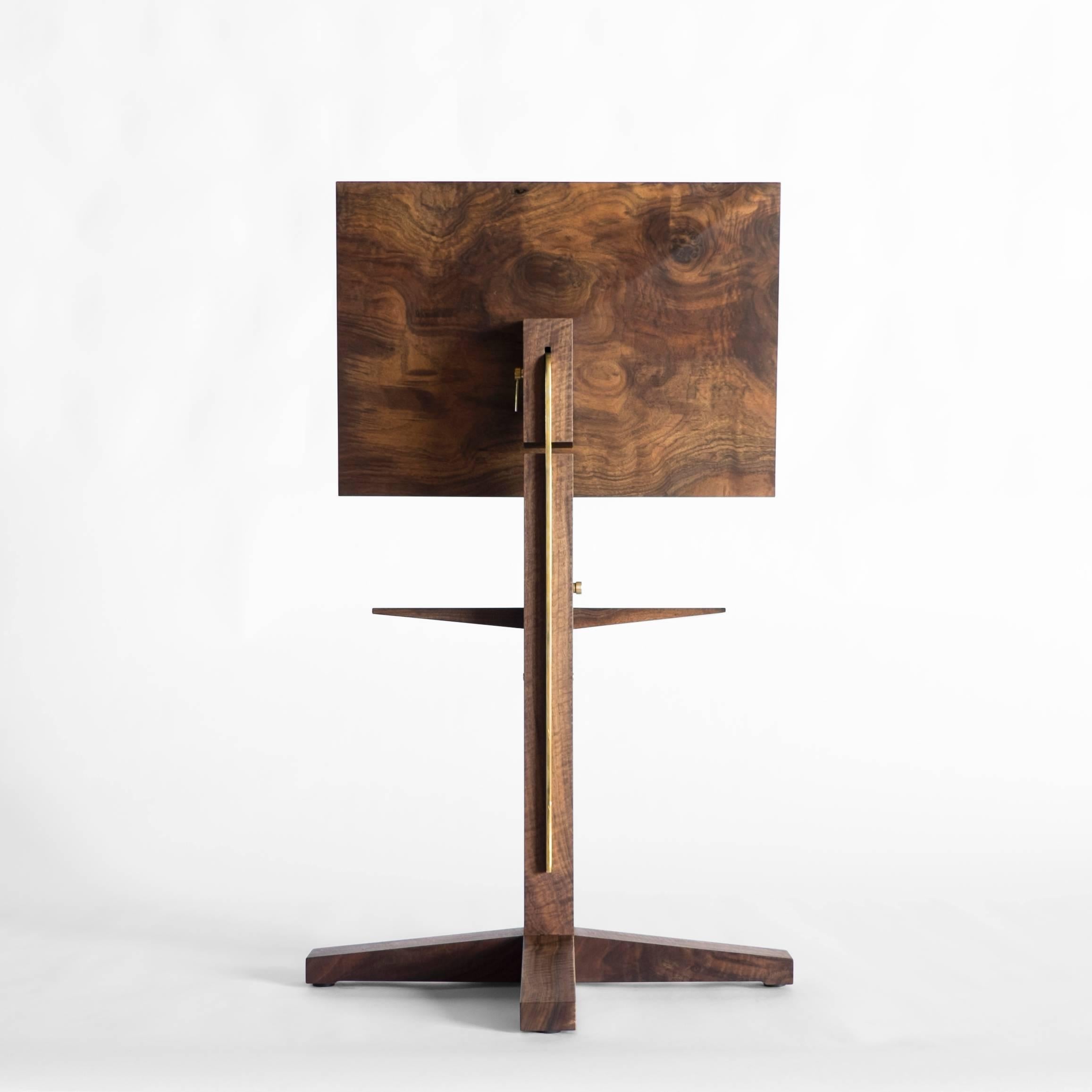 Inspired by Soviet Constructivism, this modern, sculpted California Walnut music stand by Taylor Donsker features a solid wood design with traditional hand joinery and polished brass details.  Custom, polished brass hardware allows for height and