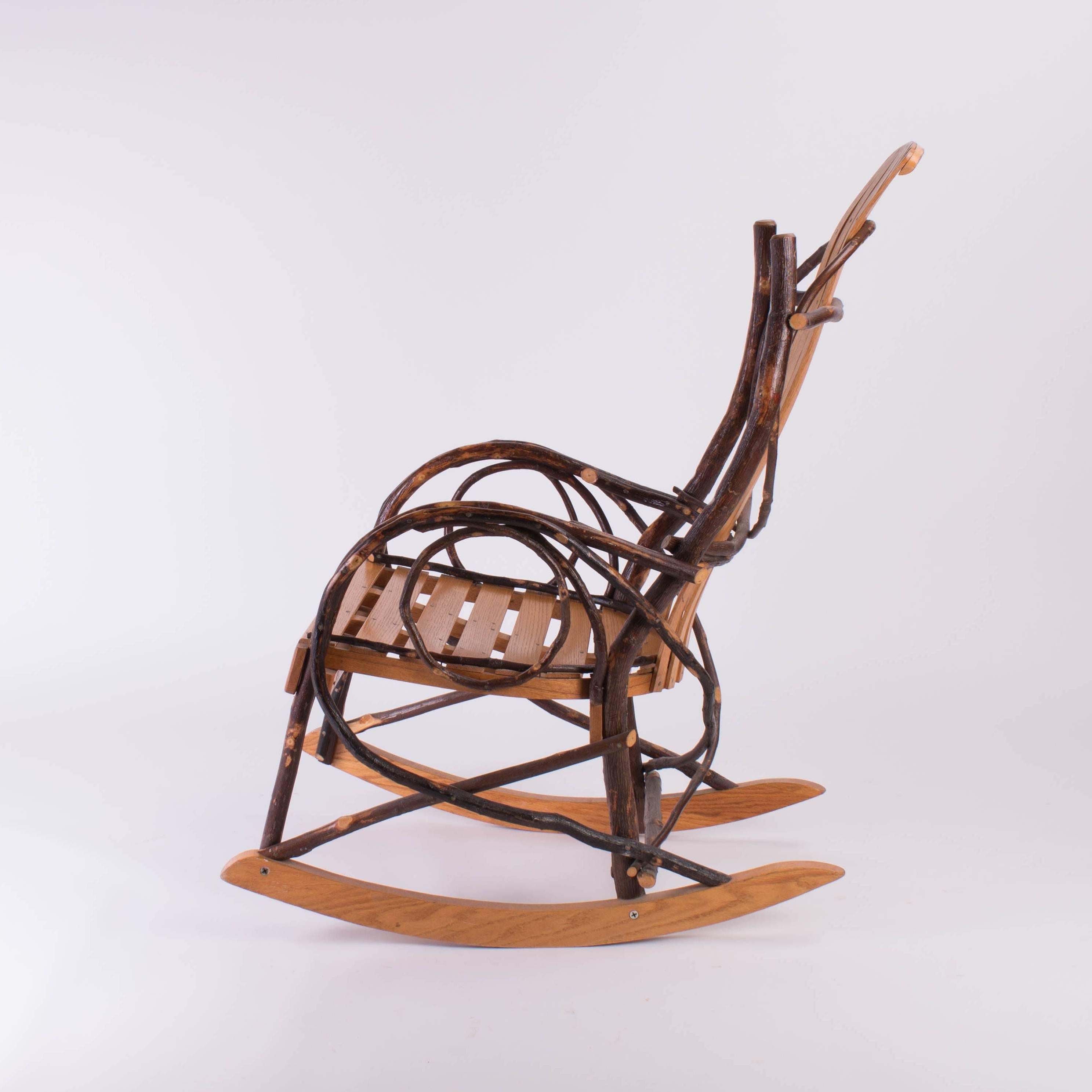Rocking chair made with slated wood and branches of a tree. 
Made by artist Lester G. Era in Millersberg, Ohio
 