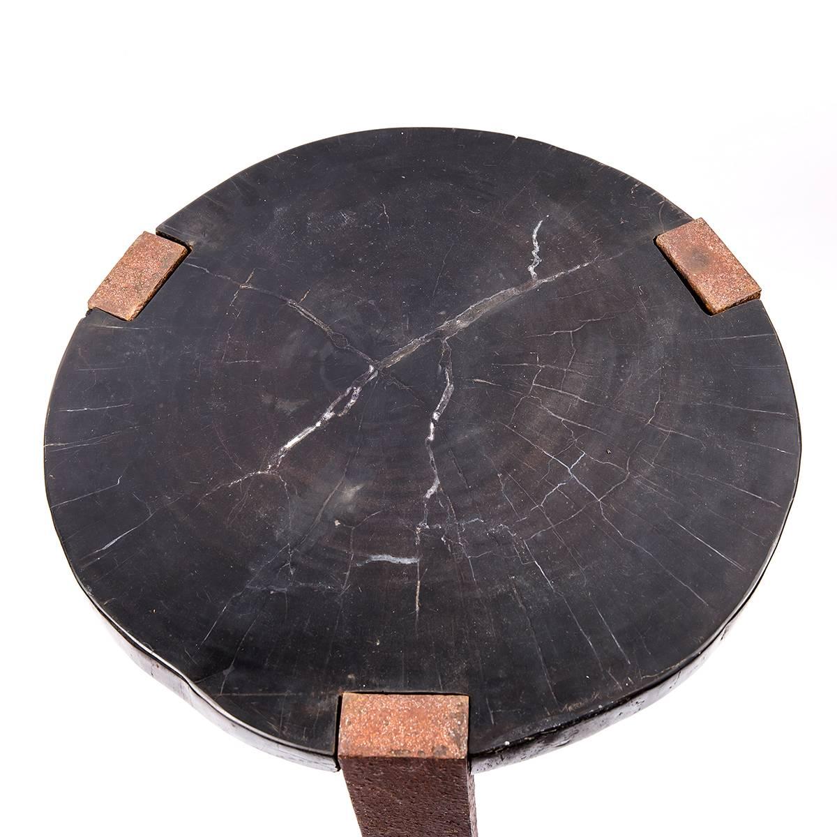 An exquisite side table is made from petrified wood and oxidized iron created by a local artist in the island Bali, Indonesia.