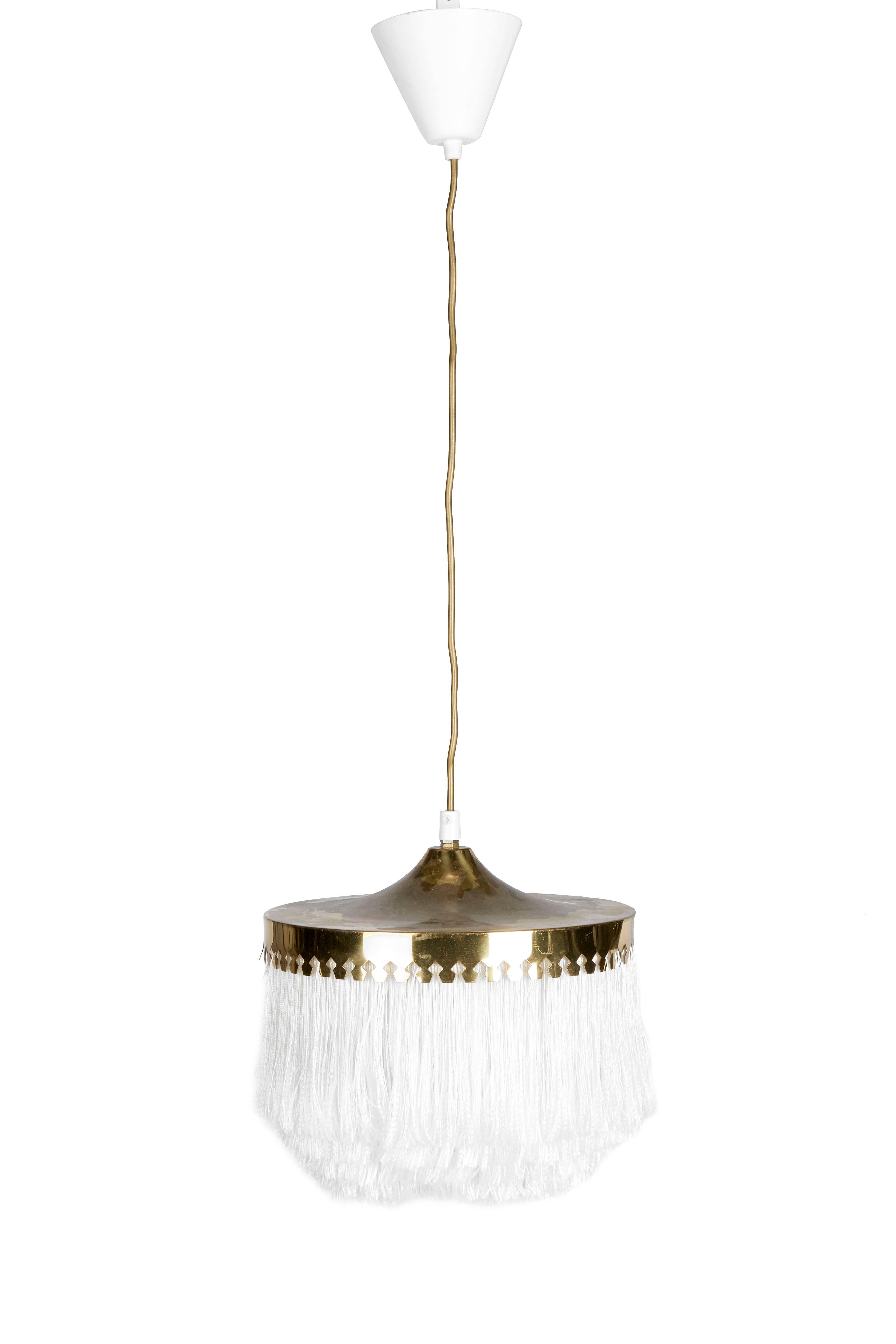 A 1950s ceiling light with brass frame and ivory silk fringes, by Hans-Agne Jakobsson for Markaryd in Sweden.

