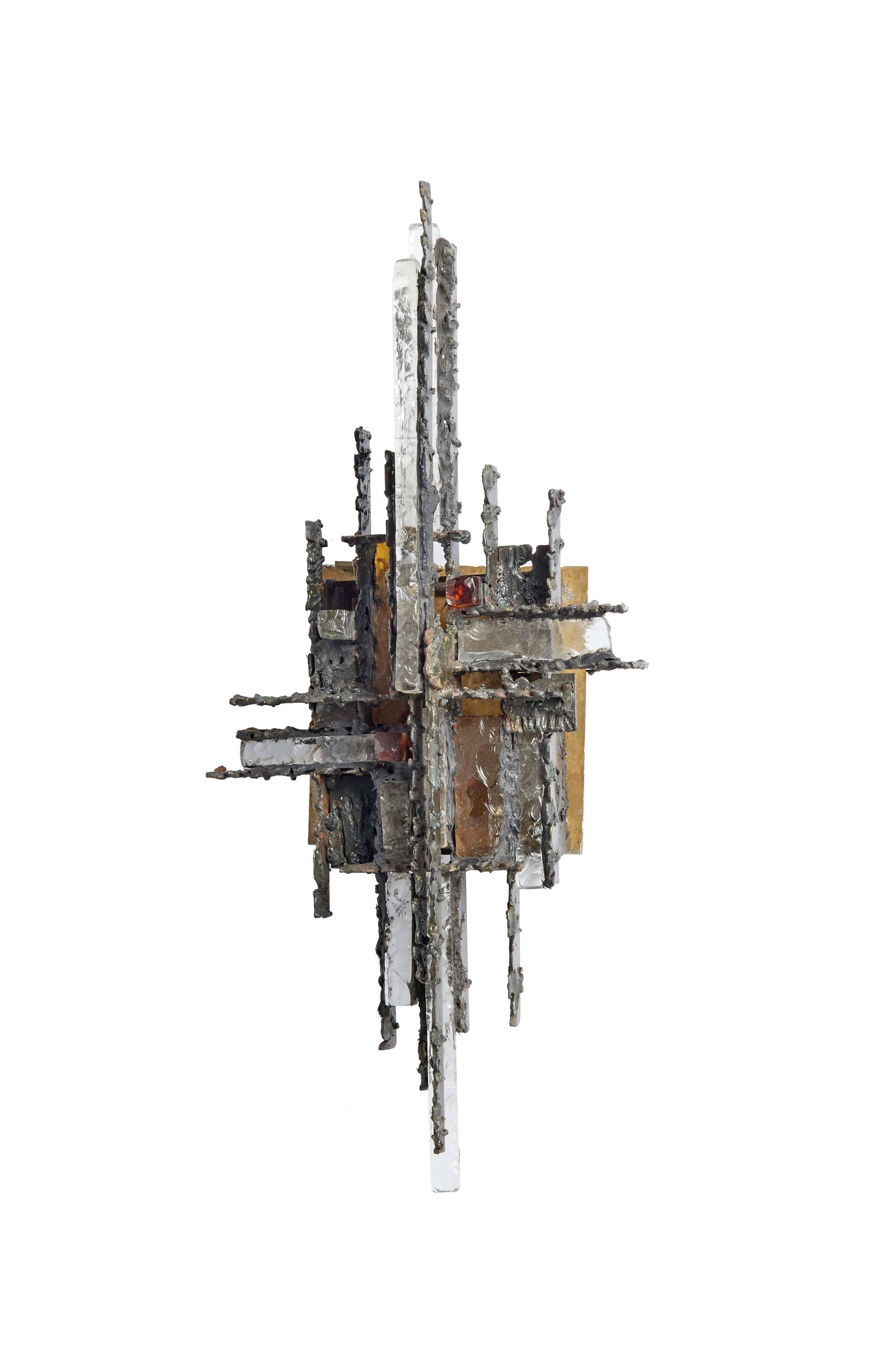 Brutalist sconce lamp designed by Biancardi & Jordan

A 1960s Italian wall sculpture made of hand-forged iron, textured glass bars in clear and colored glass.

One glass bar has a slight chip. 


 