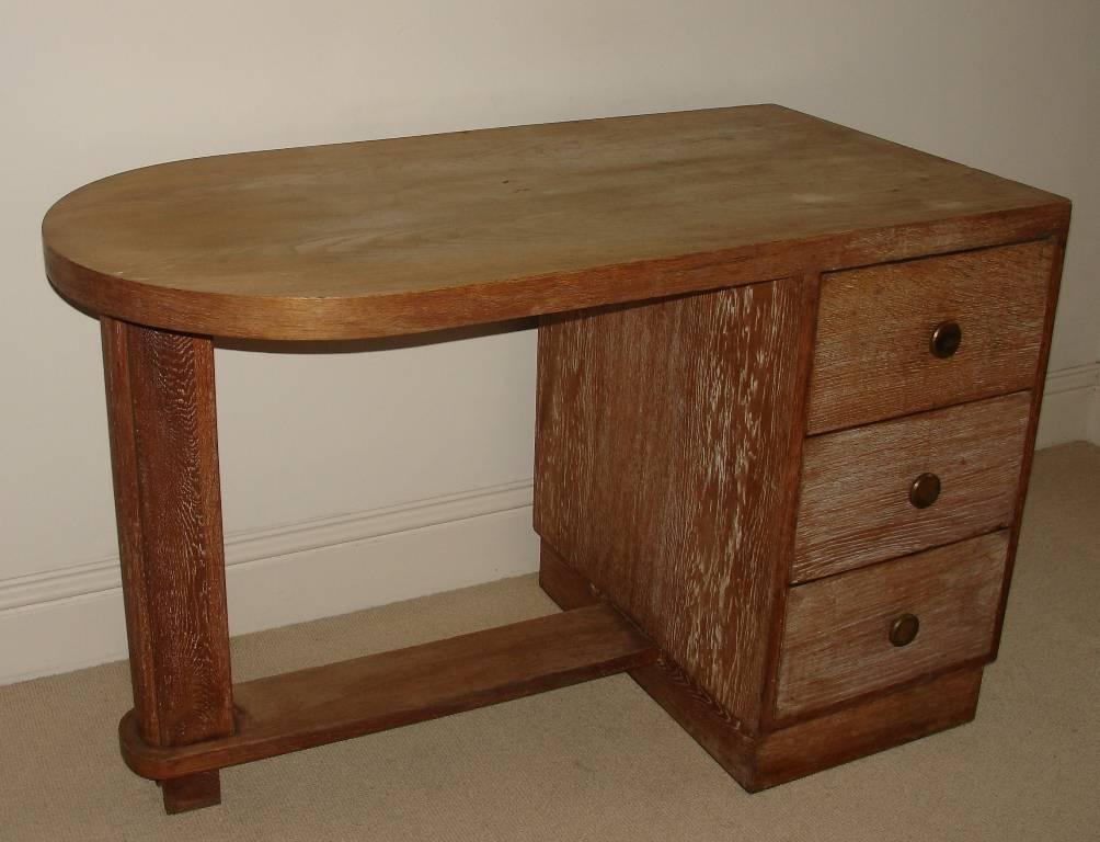 A wonderful small French Art Deco, modernist limed oak desk, with one demilune end and three drawers. Oak lined drawers. Protective glass top.