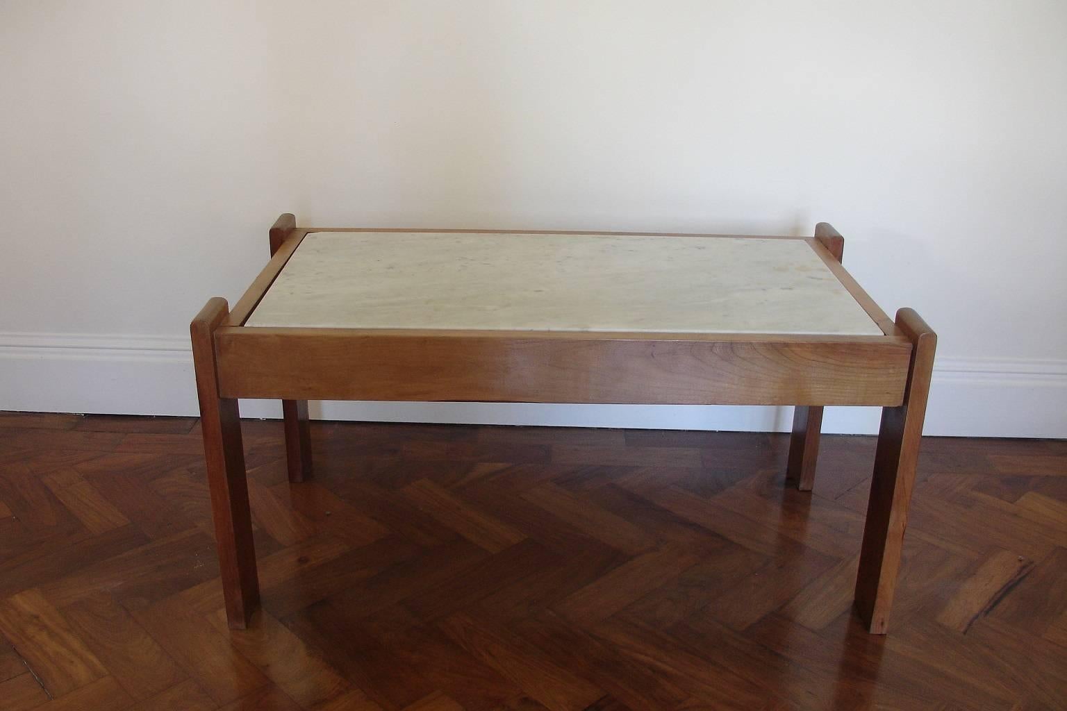 An elegant cherrywood Carrara marble coffee/centre table with bronze details. The marble is original and has some marks on the top and also a chip in the corner. It is easily replaceable. An unrestrained design, in the manner of Jacques Adnet.