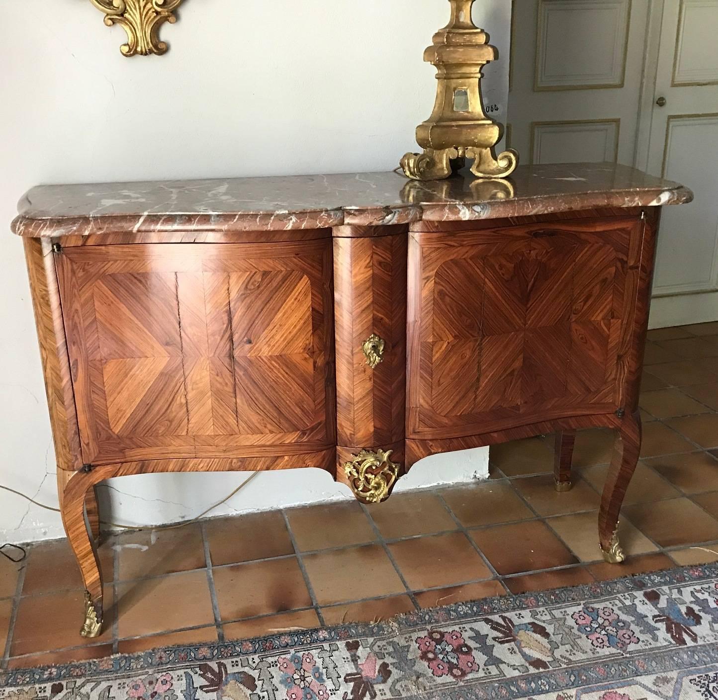 A small, elegant bookmatched marquetry veneered enfilade. Louis XV style, dating from the early 19th century. Original rose marble top and great quality bronze mounts. The marquetry is fruitwood, veneered on a solid oak base. The enfilade is in good