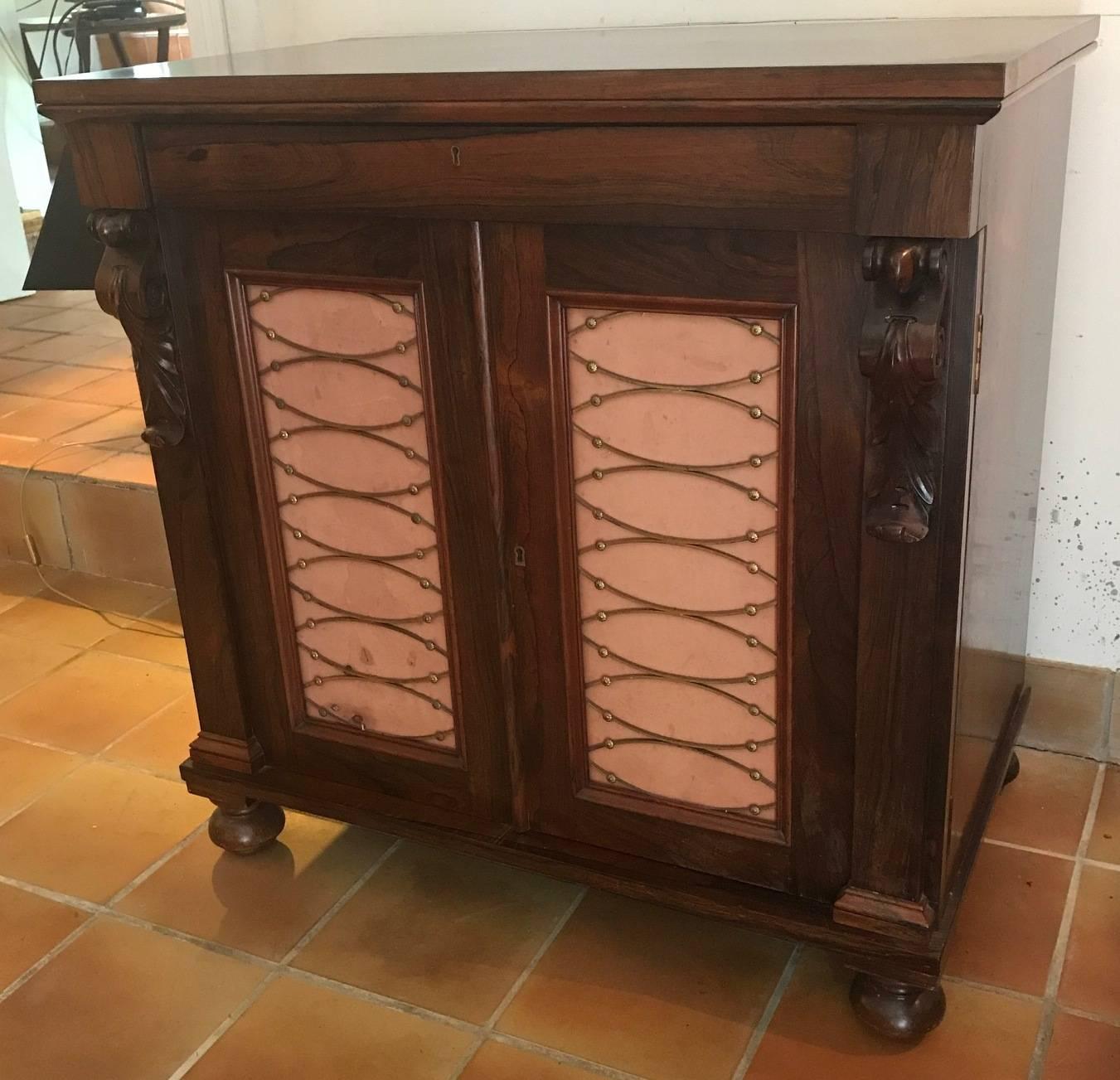A beautiful rosewood two-door chiffonier with pink silk doors and brass fretwork. Two slide drawers inside. Lovely patination to the rosewood.