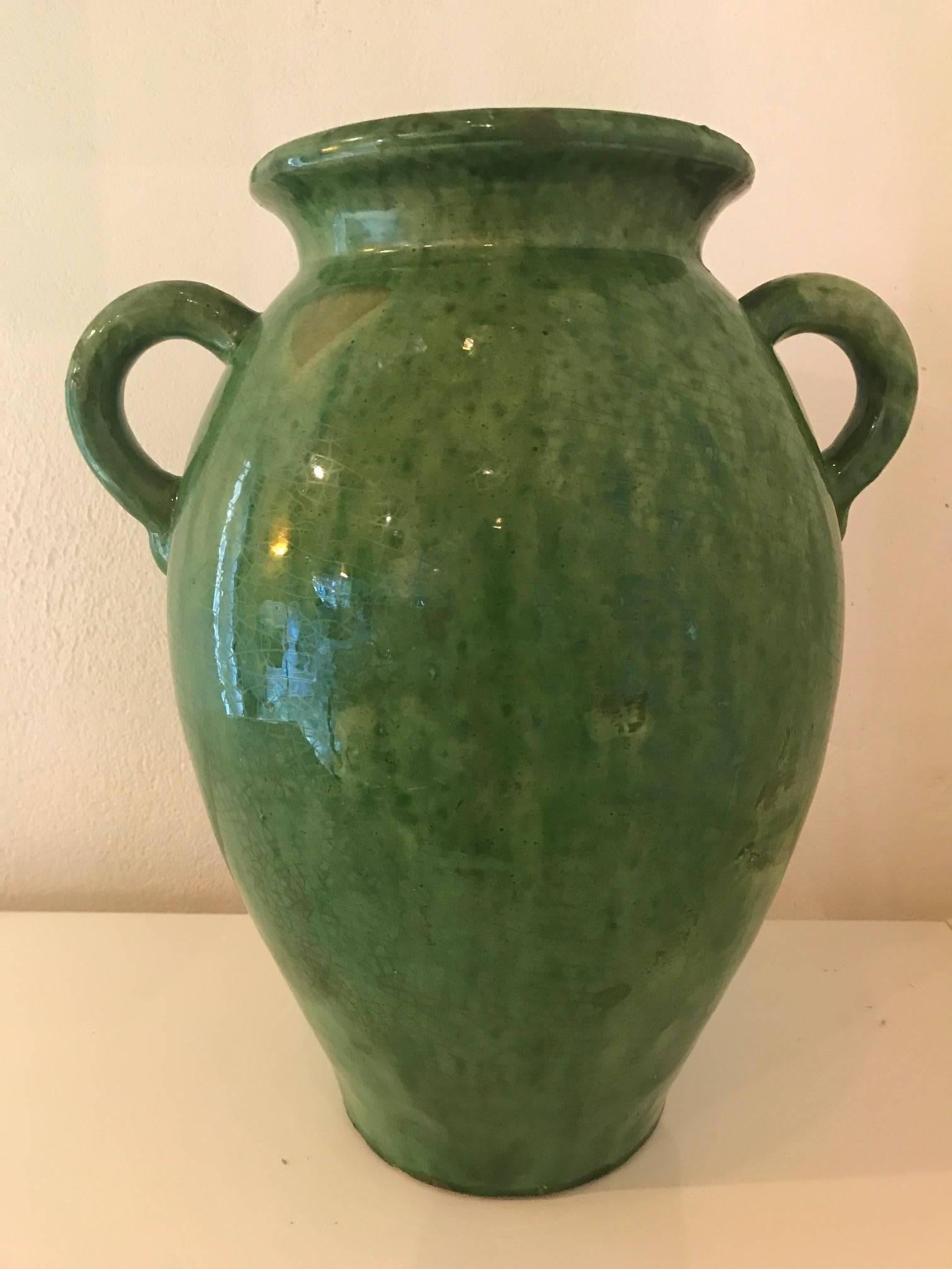 A beautiful tall green glazed ceramic vase or jug made by the French Biot Company.