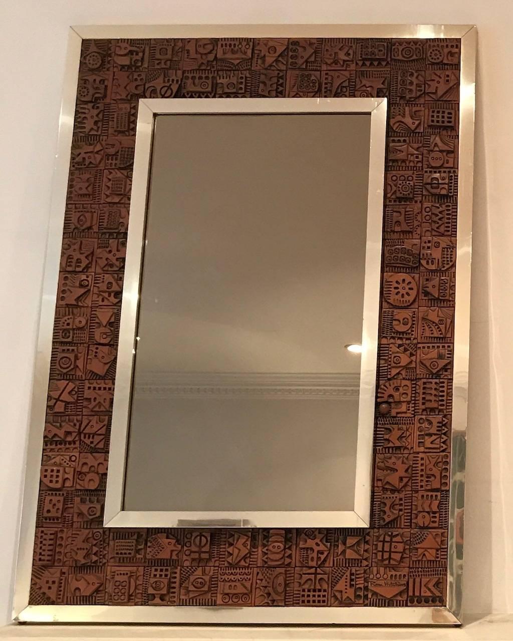 An original 1960s mirror designed by Ron Hitchens. Individual tiles inserted into an aluminium frame. One tile is signed Ron Hitchens. The mirror has a slight bronze tint.
