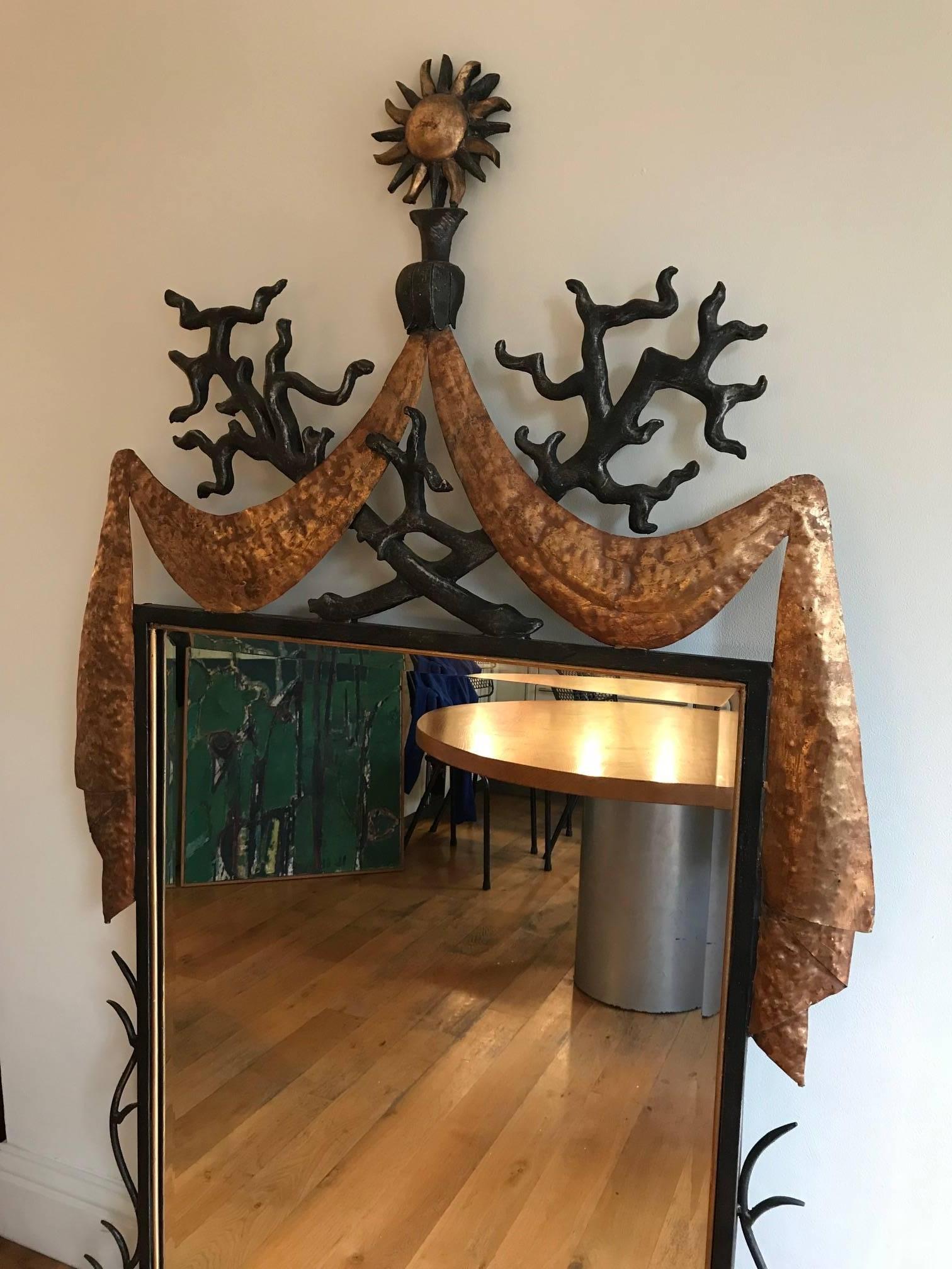 A large fantastic, decorative mirror made from iron, gilded metal and resin after a design by the French designer Gilbert Poillerat.