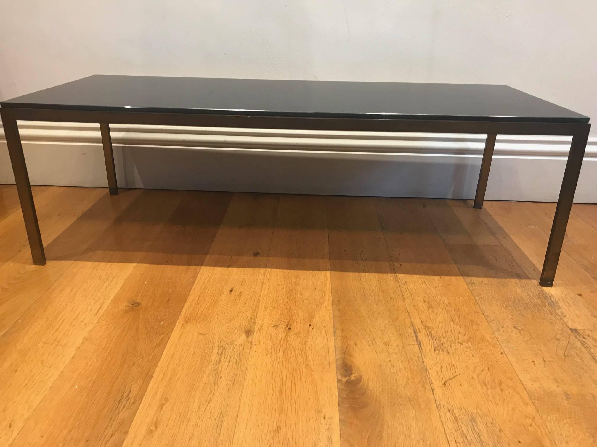 A very sleek and elegant solid bronzed metal and black glass coffee table, French, circa 1950s.