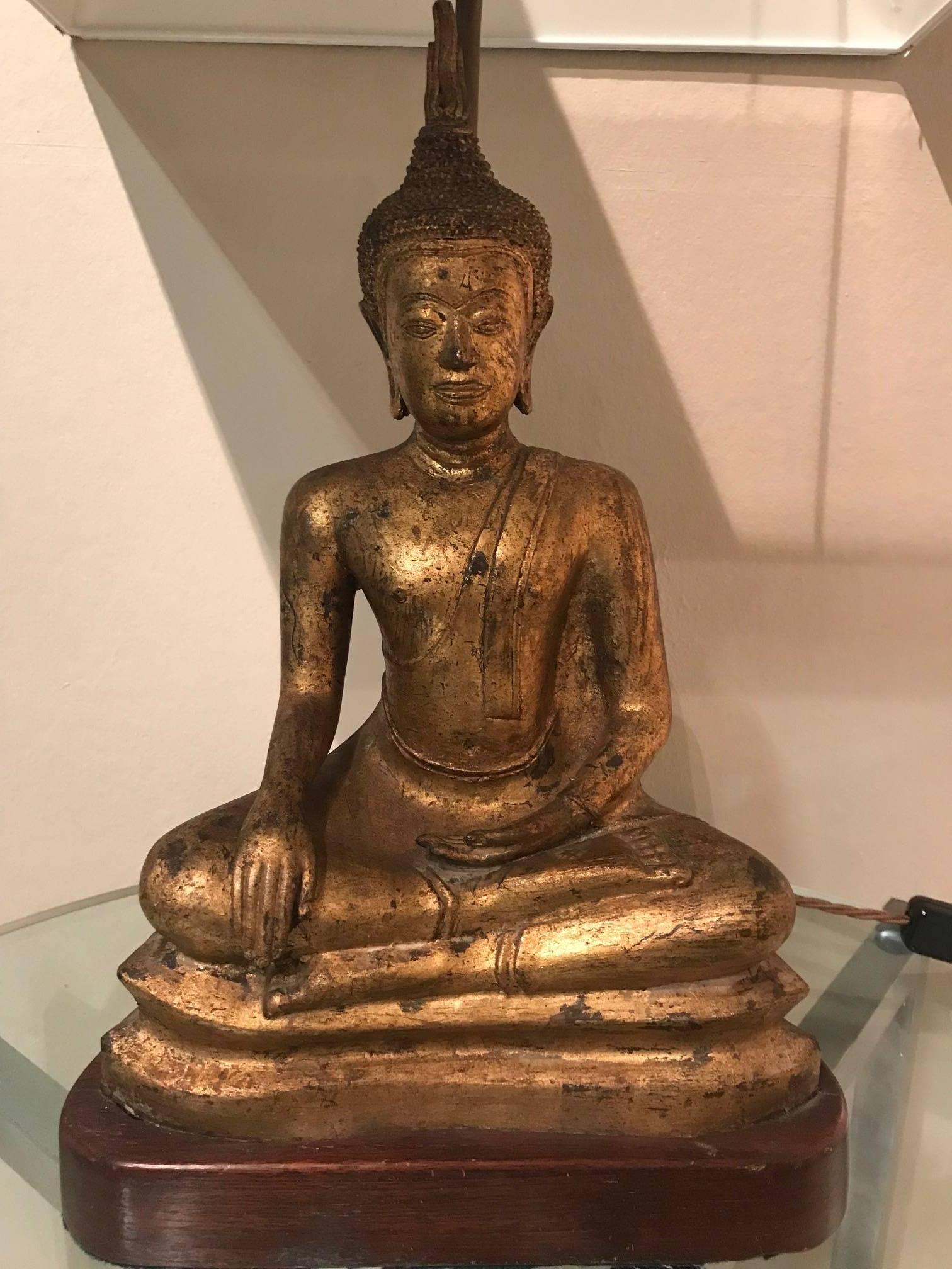 A very good quality gilded metal Buddha lamp seated on a wooden base, French, circa 1970s.