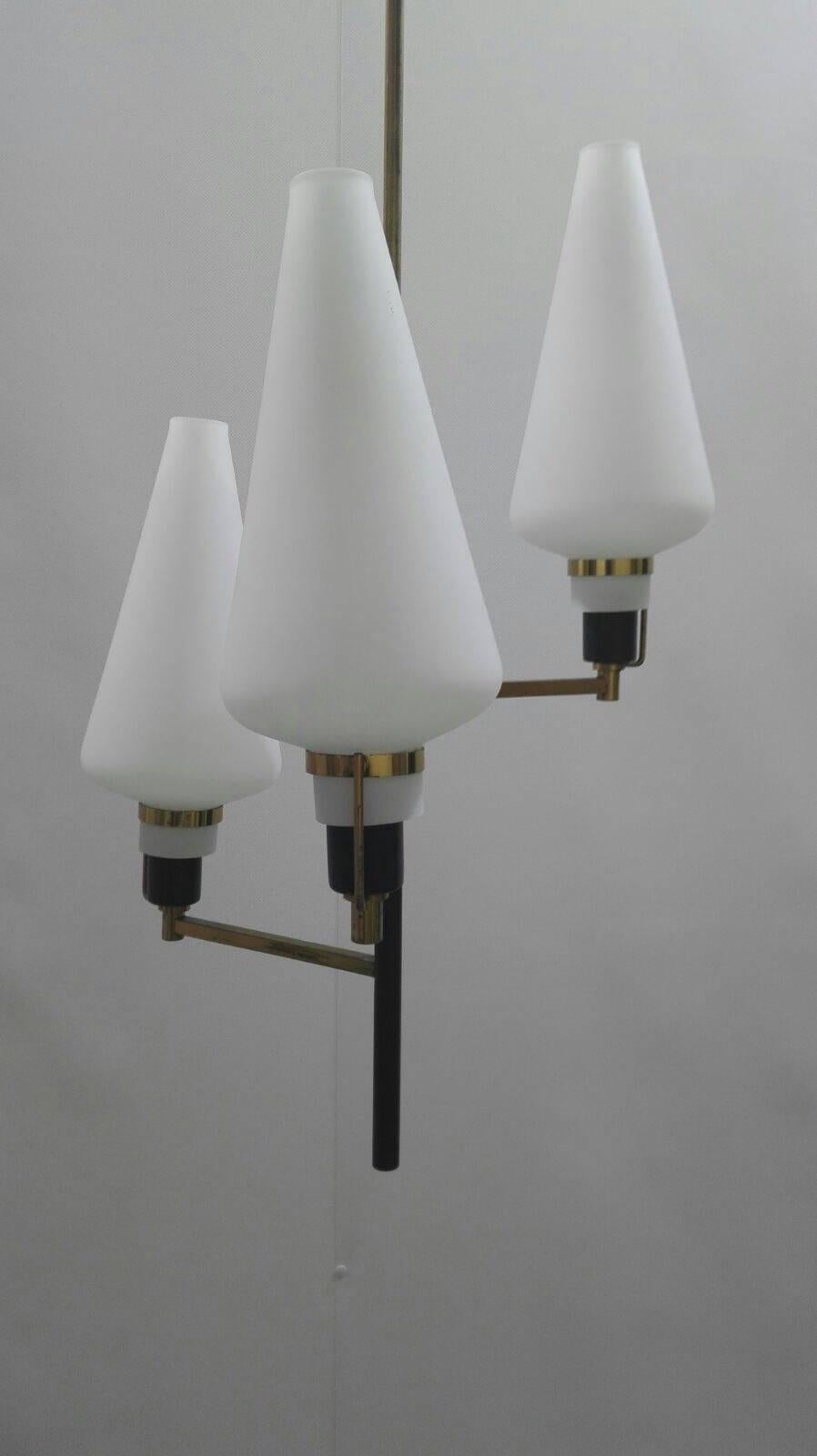 Three-lamp chandelier with brass finish and opal glass shades.